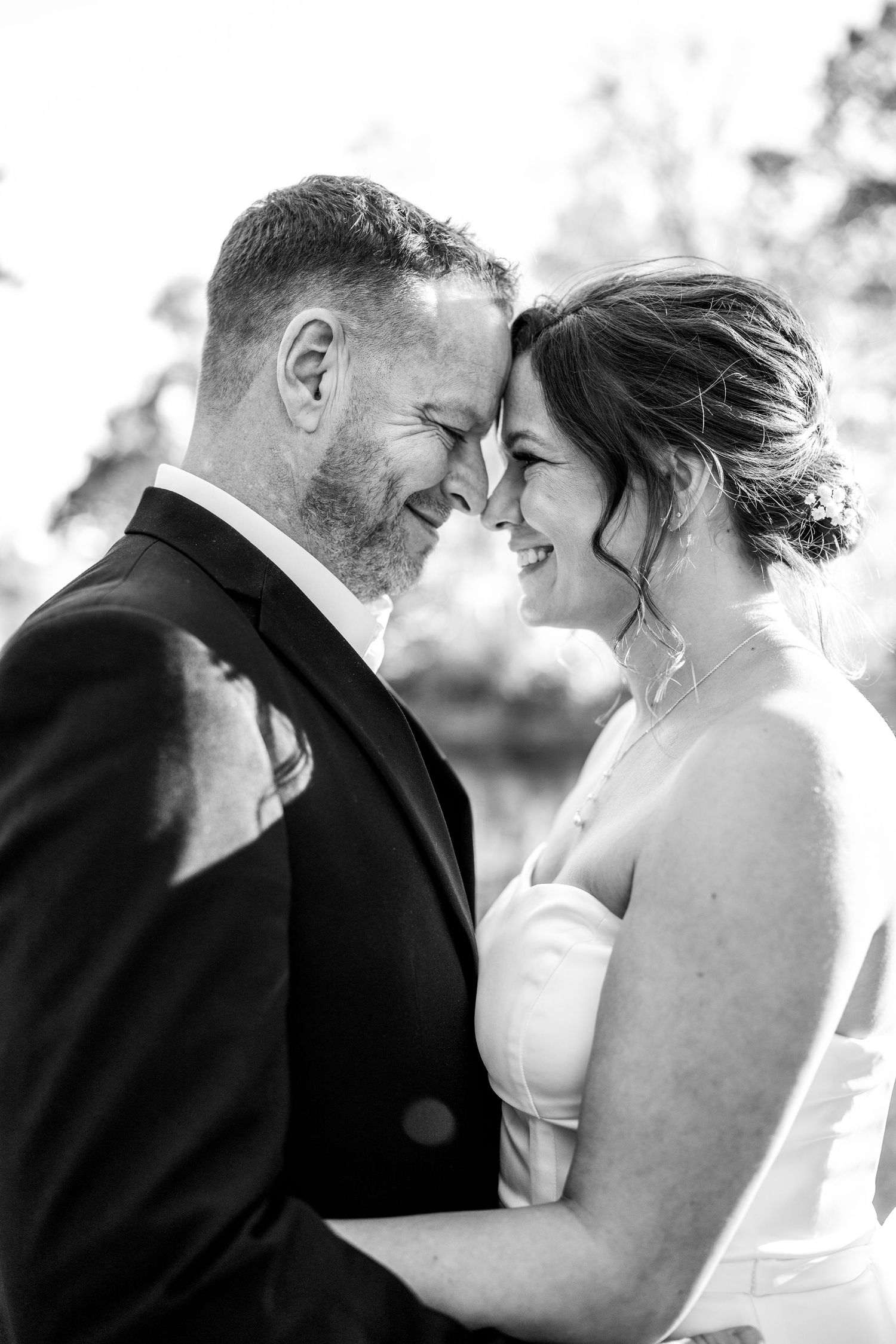 philadelphia wedding photography  Black and white photo of smiling bride and groom touching foreheads on their wedding day.