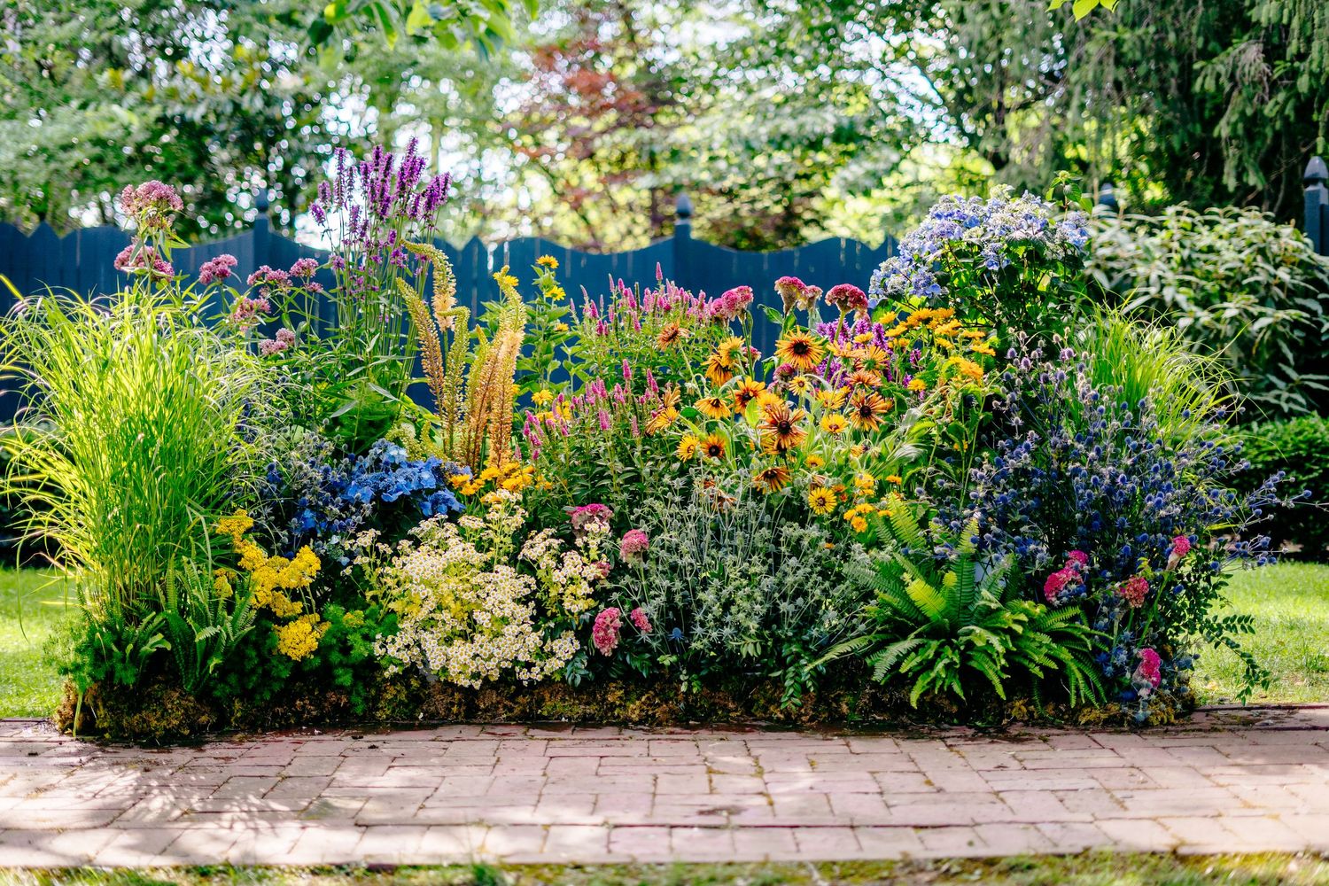Fernbrook farms Philly wedding photography garden border bursting with colorful summer flowers including yellow, pink, and blue blooms