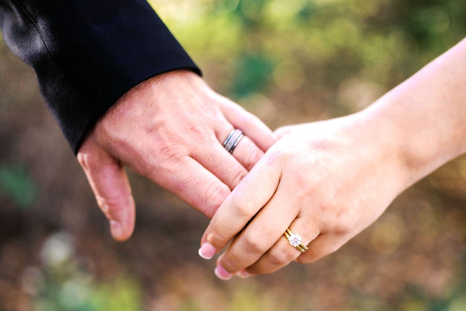 philadelphia wedding photography  Close-up of a married couple holding hands, both wearing wedding rings, symbolizing love and commitment.