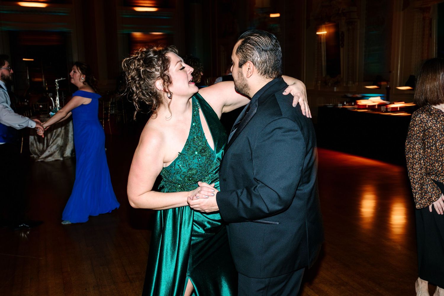 Hotel DuPont wedding Couple dancing joyfully at a wedding reception, woman in emerald green gown, man in black tuxedo.
