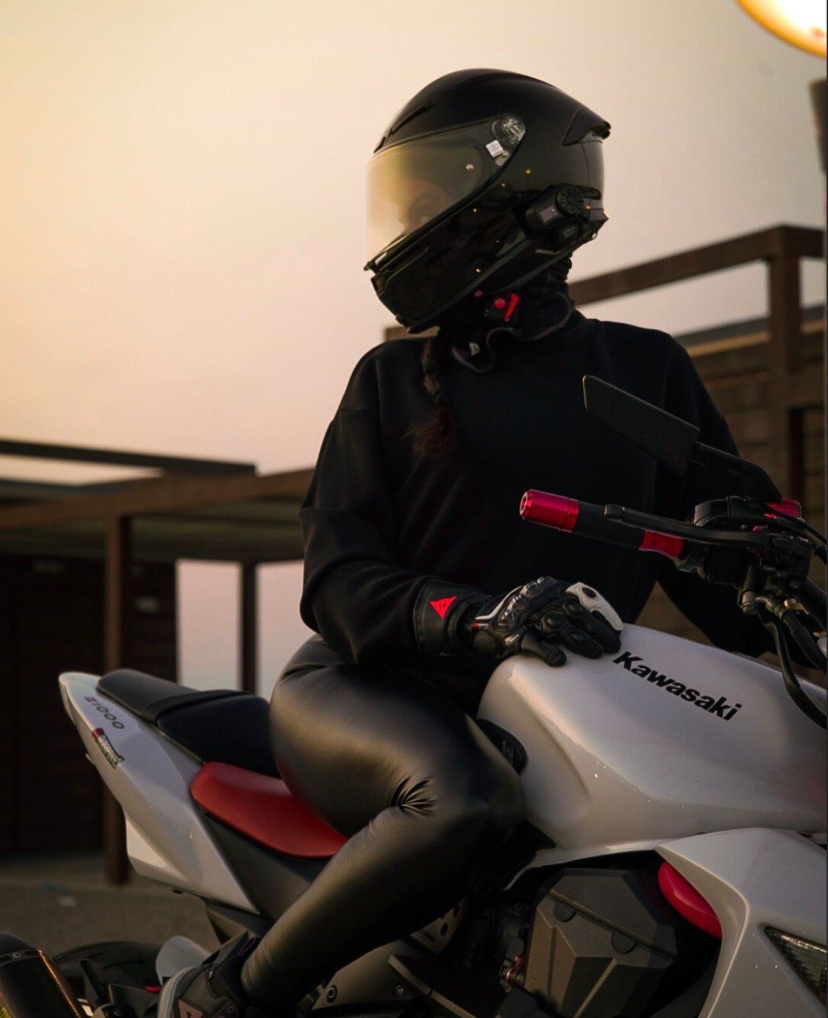 Person in black gear and helmet sitting on white Kawasaki motorcycle at dusk.

portrait