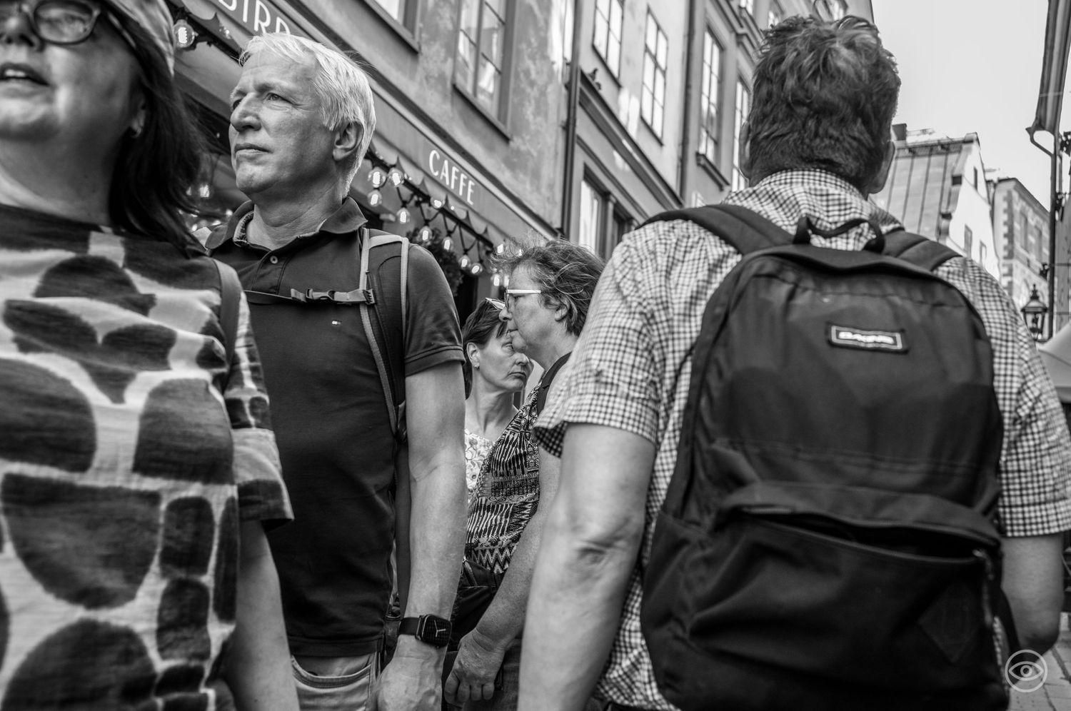 Crowd of people walking through a busy shopping street captured in black and white street photography.
