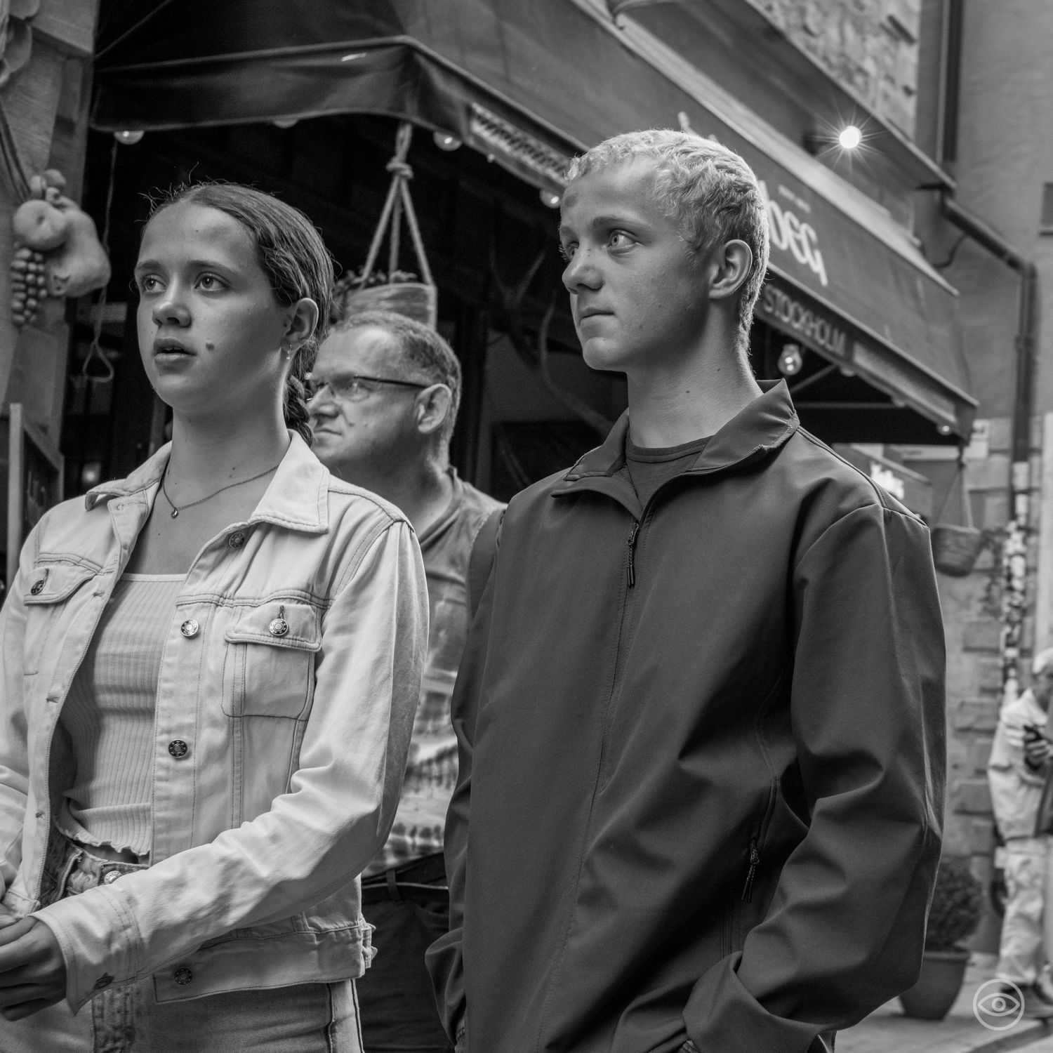 Young man and woman walk together on a busy street in black and white urban street photography.