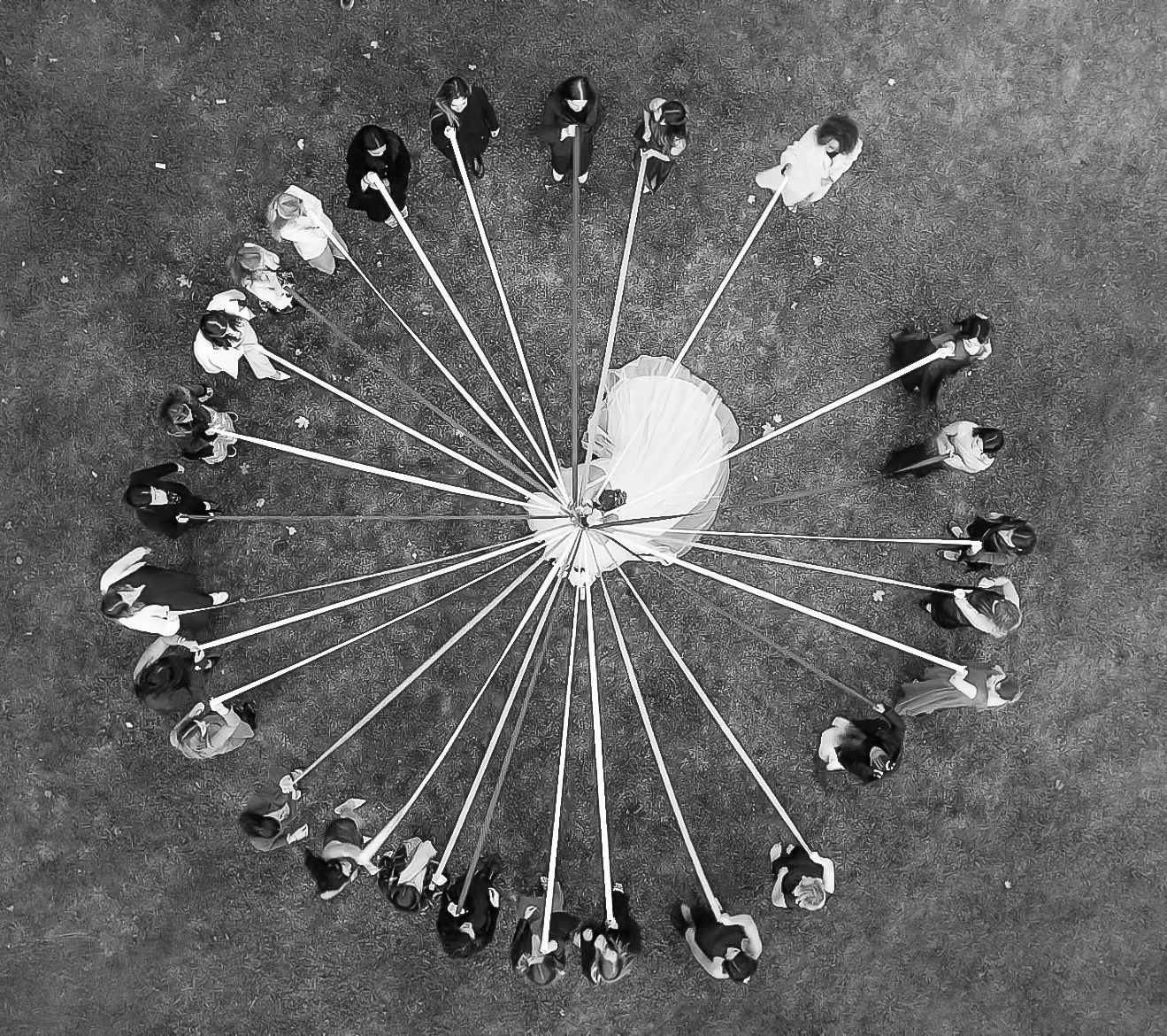 Photo de groupe en noir et blanc vue du ciel, les invités en cercle autour des mariés - jeu du rubans — photographe mariage Lorraine