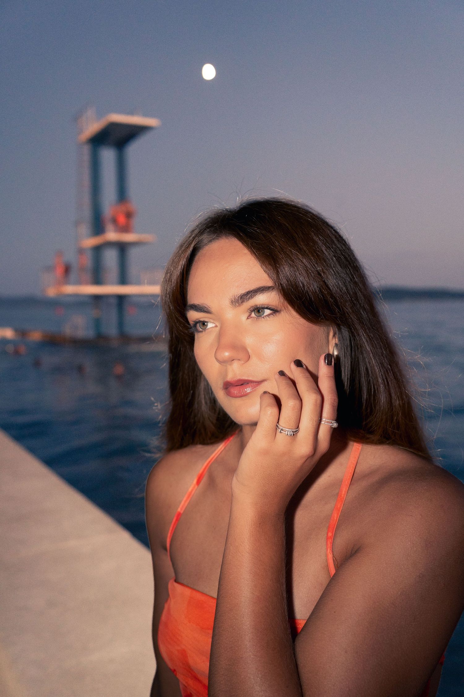 Portrait bijoux au bord de la mer, main près du visage à l'heure bleue — photographie lifestyle