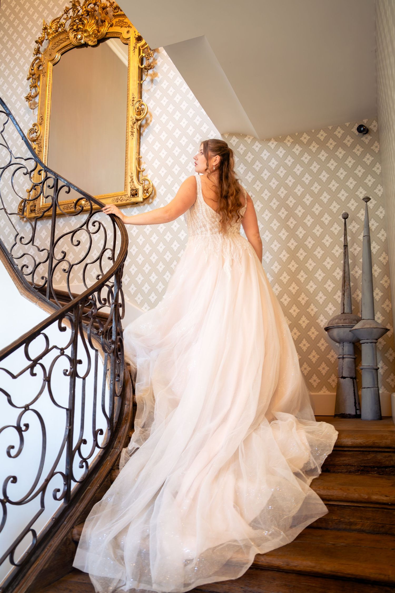 Photo d'une mariée en robe à traîne dans un escalier d'honneur — photographe mariage Luxembourg