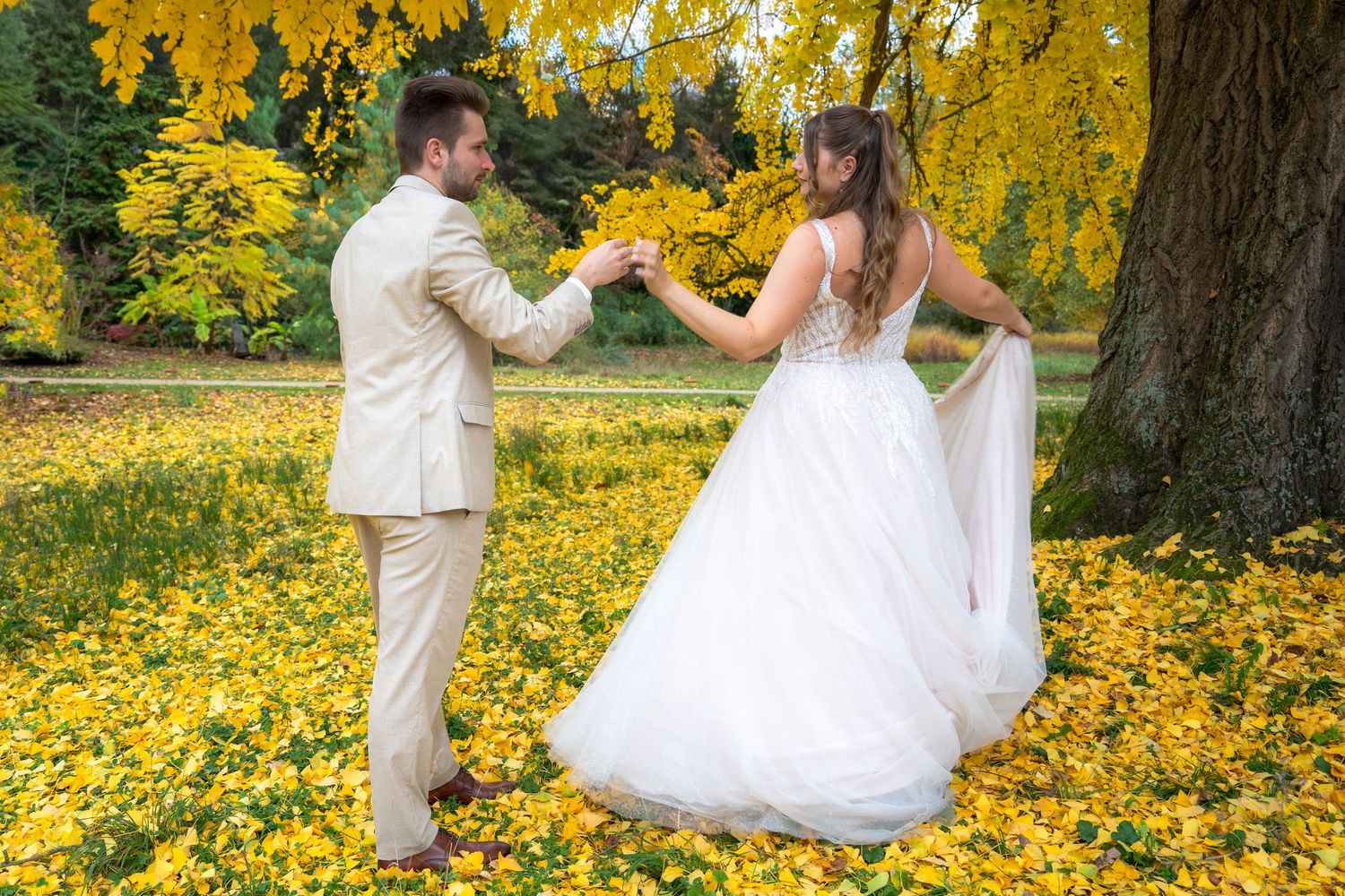 Photo des mariés dansant sur un tapis de feuilles dorées — photographe mariage Lorraine
