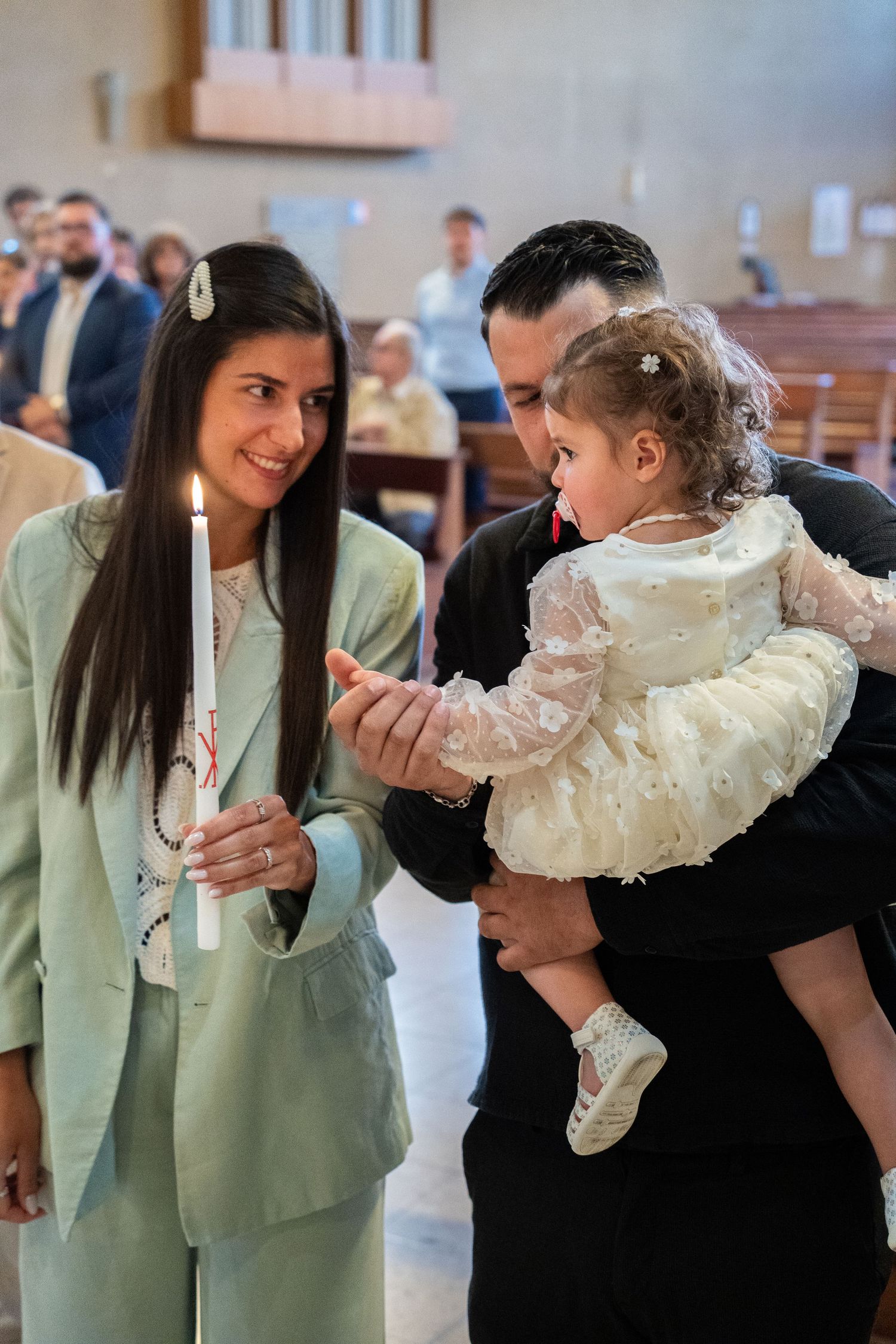 Moment de complicité entre une marraine et l'enfant pendant la cérémonie — photographe baptême Lorraine et Luxembourg
