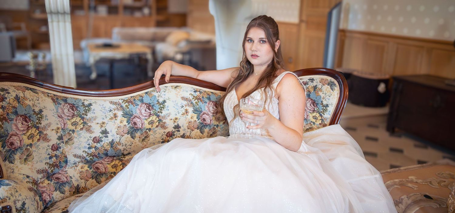 Mariée en robe de tulle posant sur un canapé fleuri dans un salon ancien – photographe de mariage en Lorraine et Luxembourg