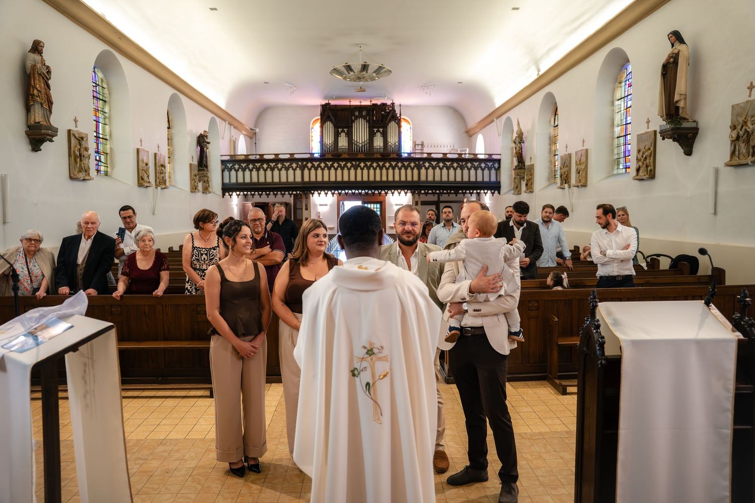 Célébration de baptême dans une église de village, famille réunie devant l'autel — photographe baptême Lorraine