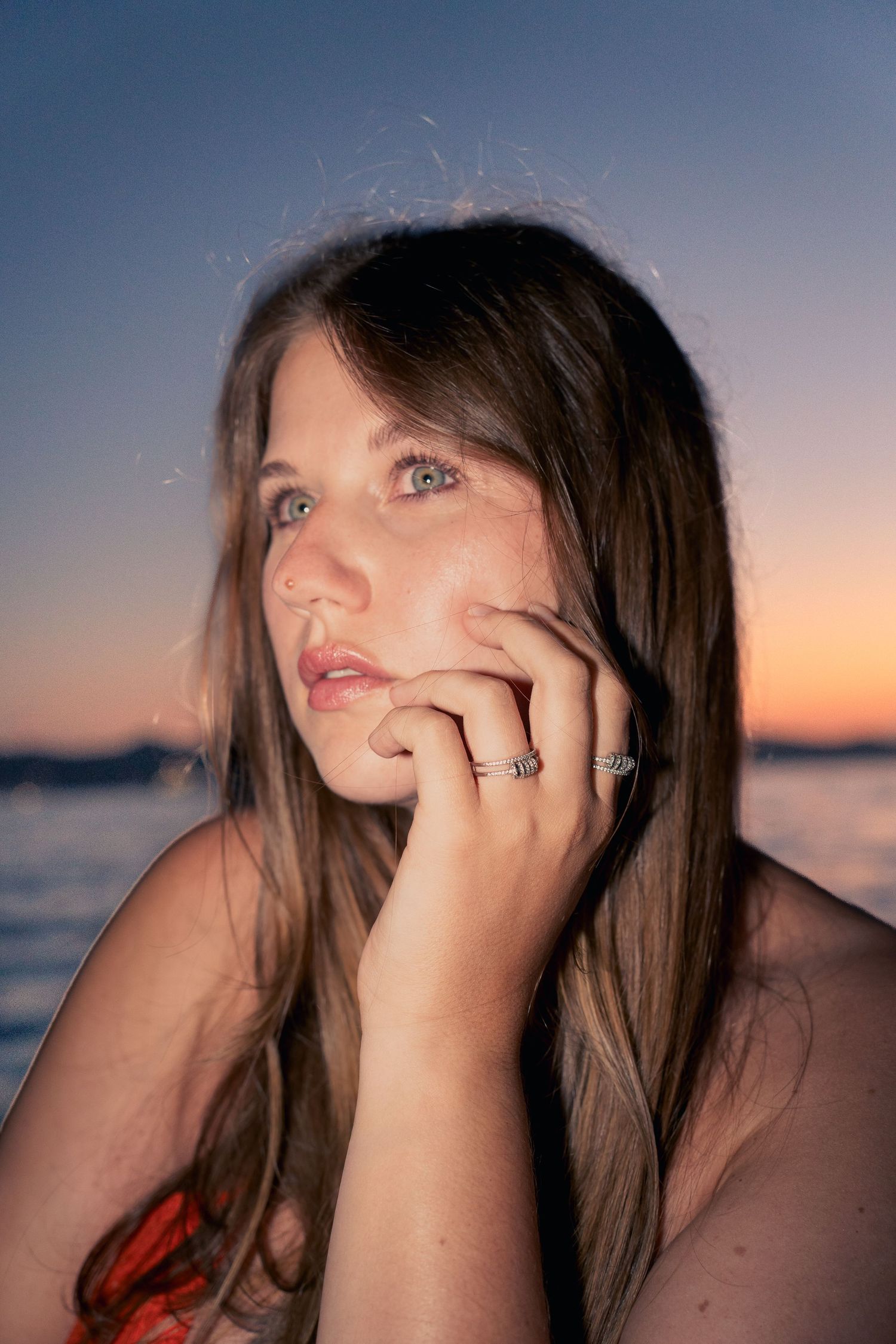 Portrait bijoux au bord de la mer, main près du visage à l'heure bleue — photographie lifestyle