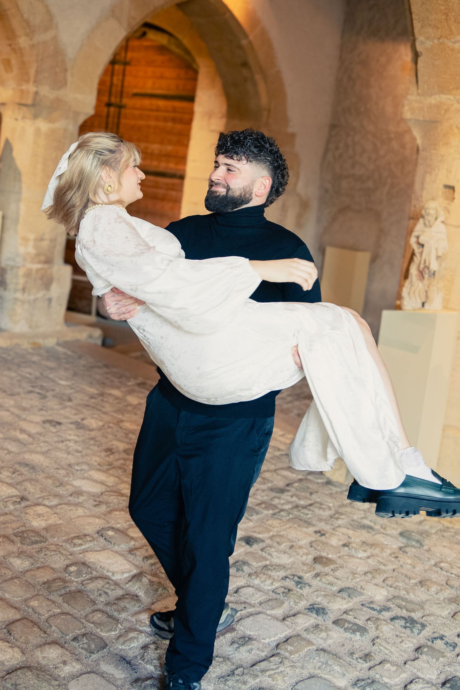 Photo du marié portant la mariée sous les voûtes de pierre — photographe mariage Lorraine