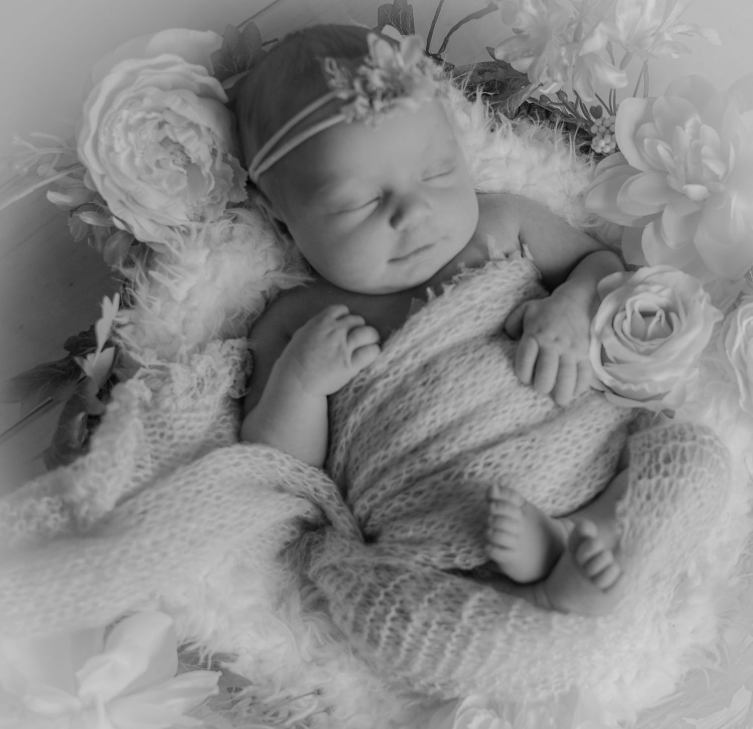 Sleeping newborn baby wrapped cozily in white with a matching bonnet by Tiny Toes to Tassels Photography