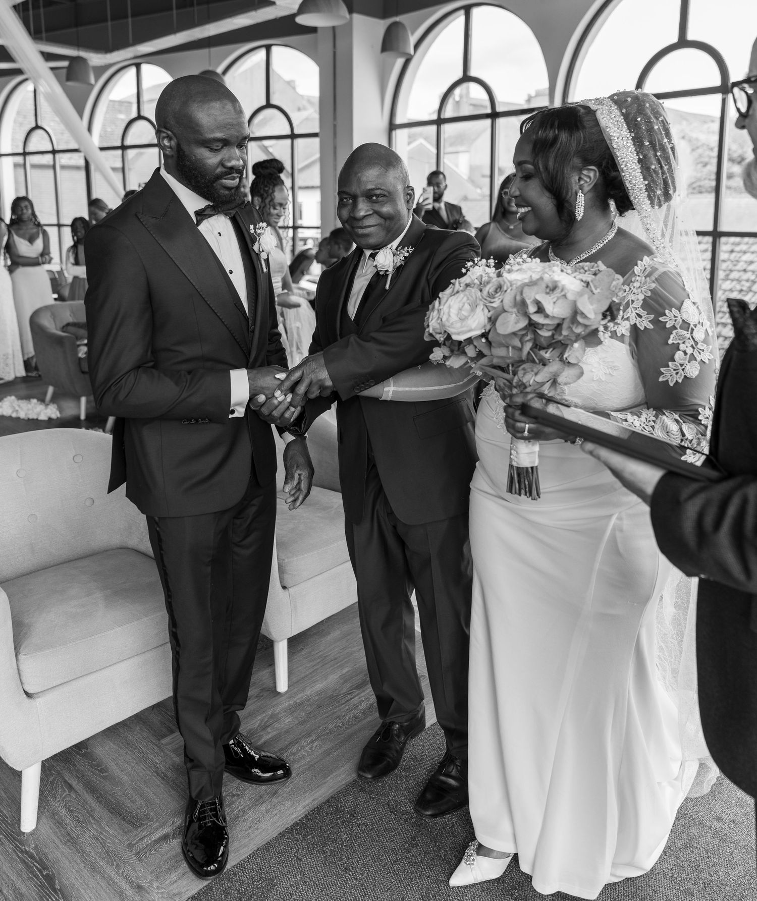 Bride’s father placing her hand in the groom’s during an emotional wedding ceremony moment.