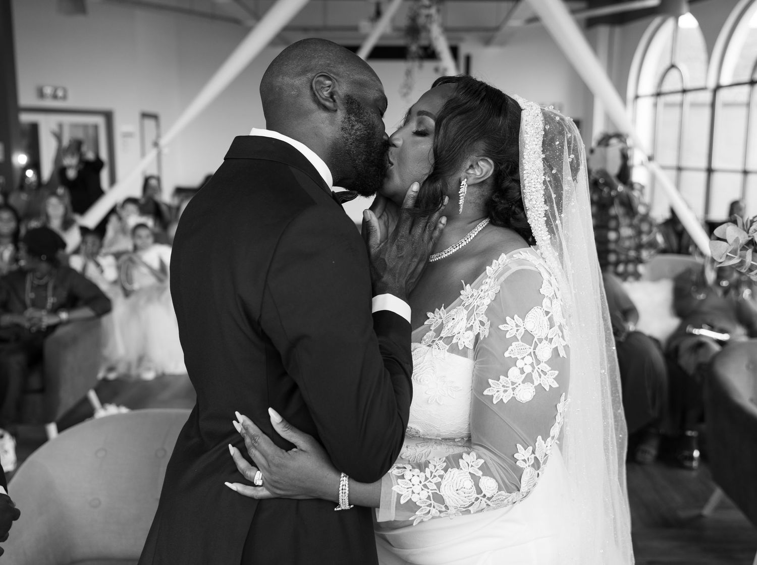 Bride and groom sharing their first kiss as a married couple during their joyful wedding ceremony.