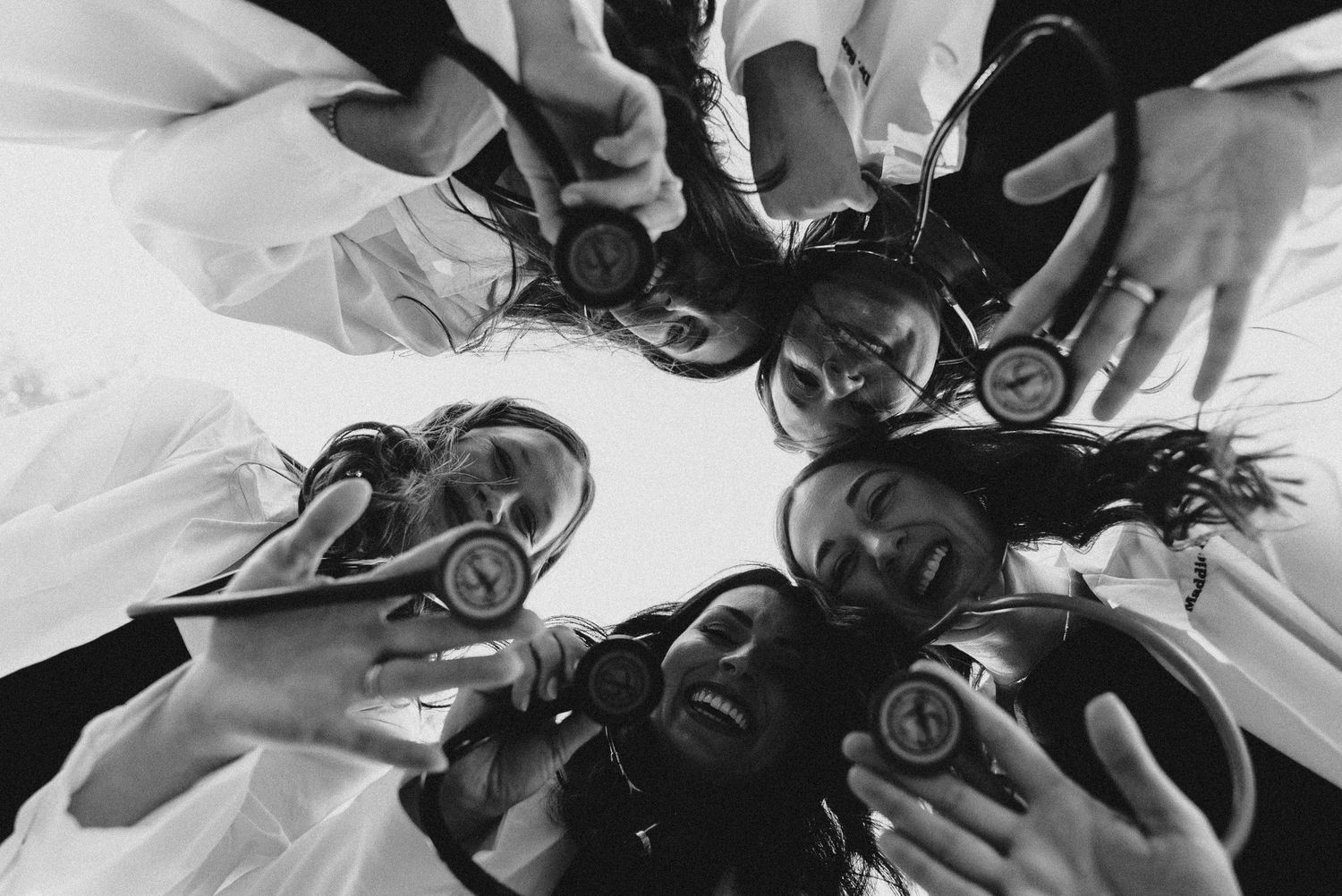 DVM graduation photography featuring veterinary students listening to stethoscopes while looking down at the camera.