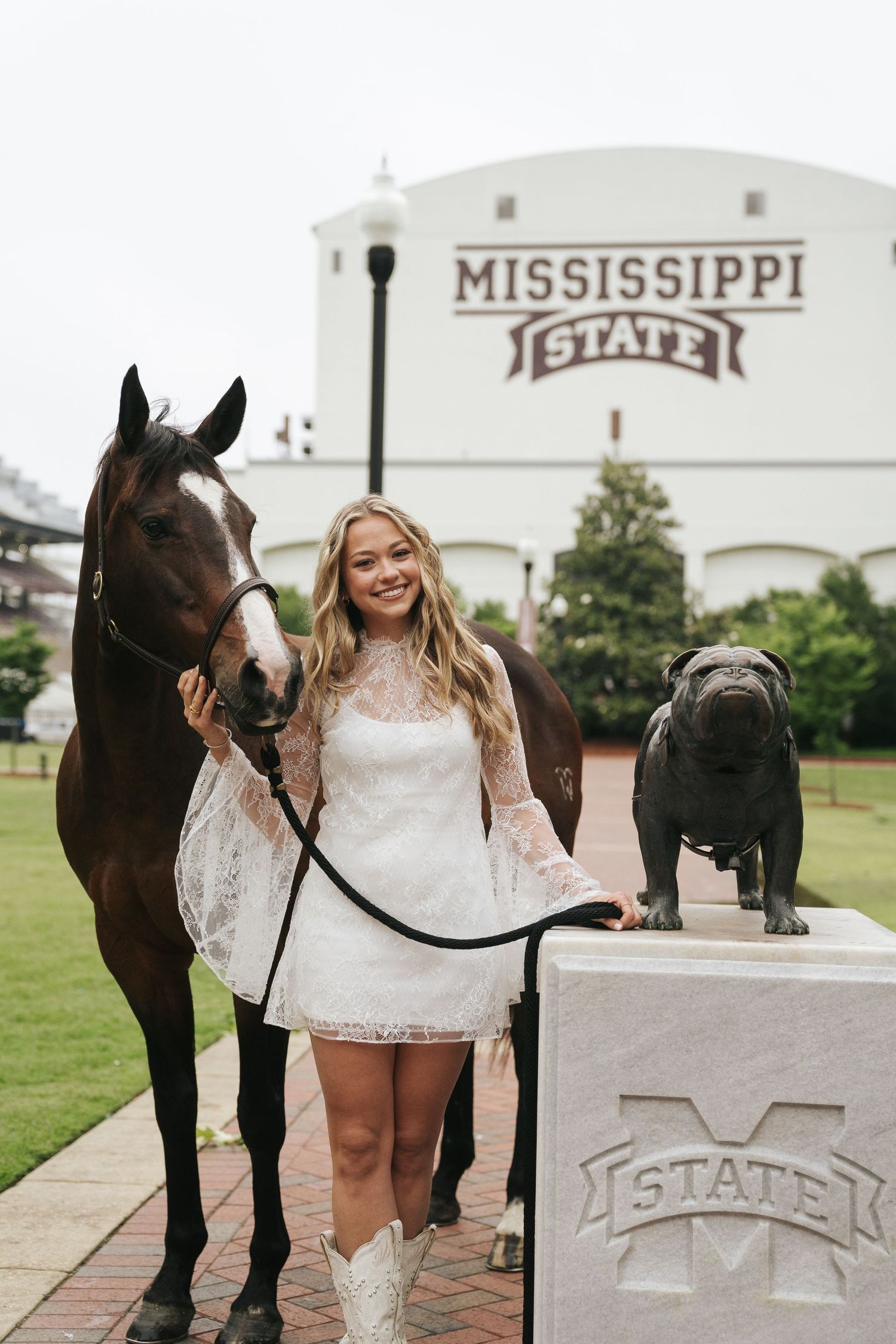 Graduation portrait photography in Starkville, MS, featuring a graduate with her horse on Mississippi State University campus.