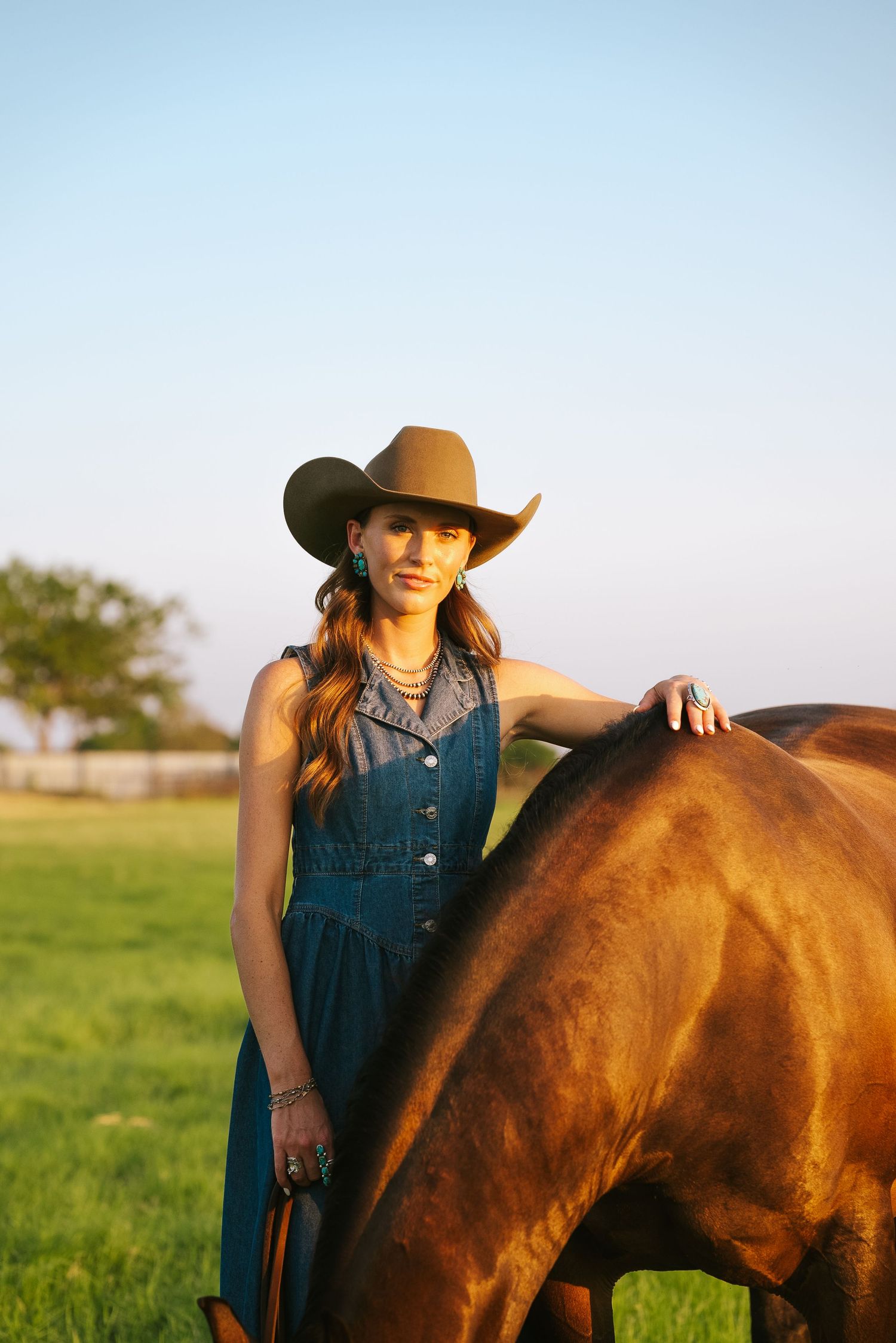 Golden hour equine portrait photography featuring a girl leaning against her horse in a warm, golden glow.