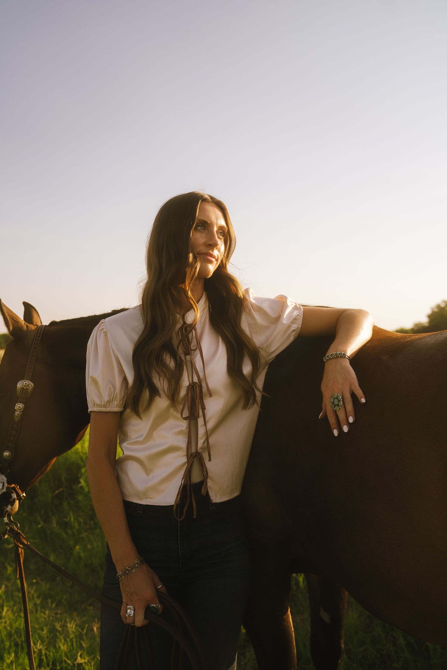 Portrait photography in Weatherford, Texas, featuring a girl posing with her horse during golden hour.