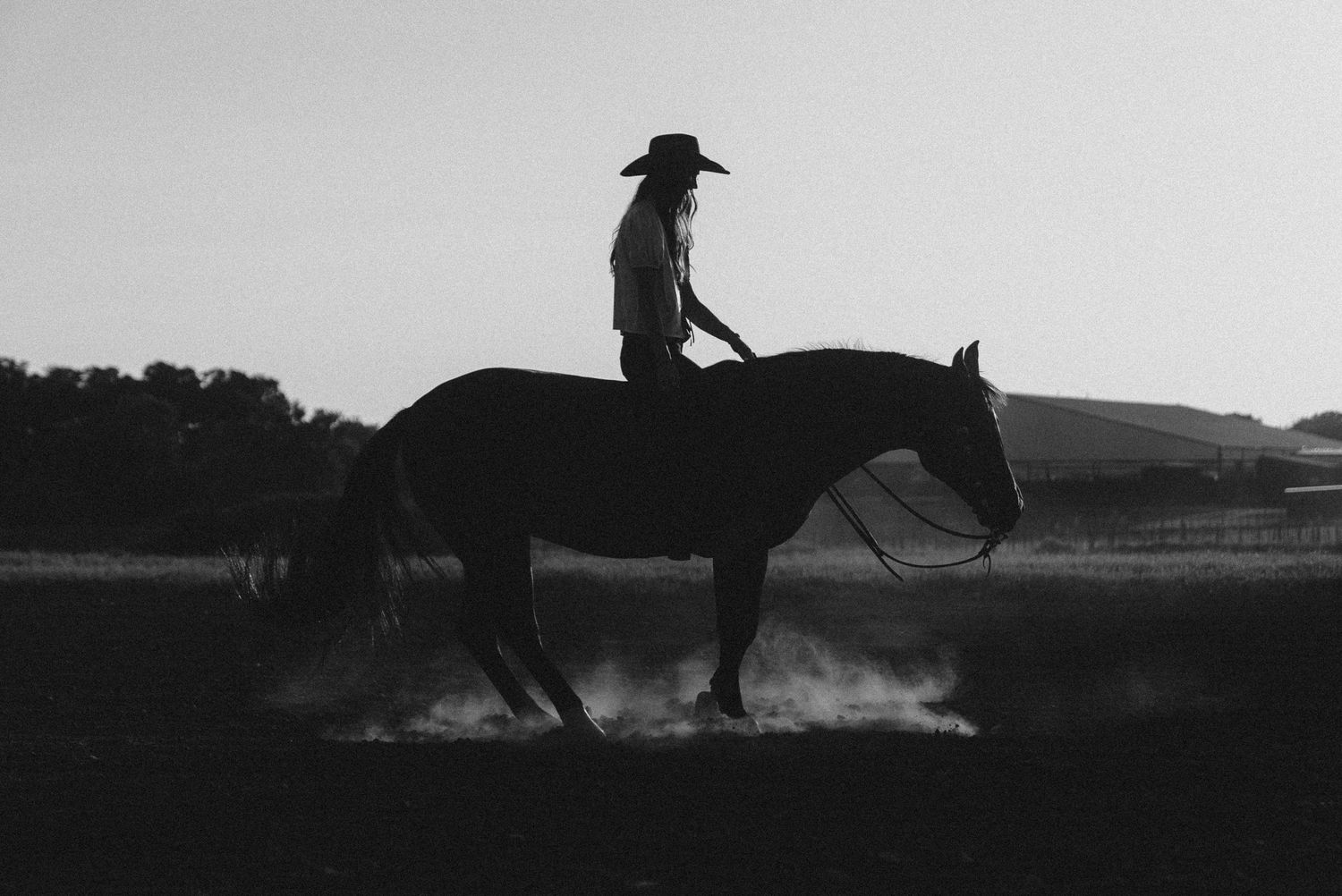 Black and white equine photography of a horse and rider performing reining turns in an arena in Weatherford, Texas.