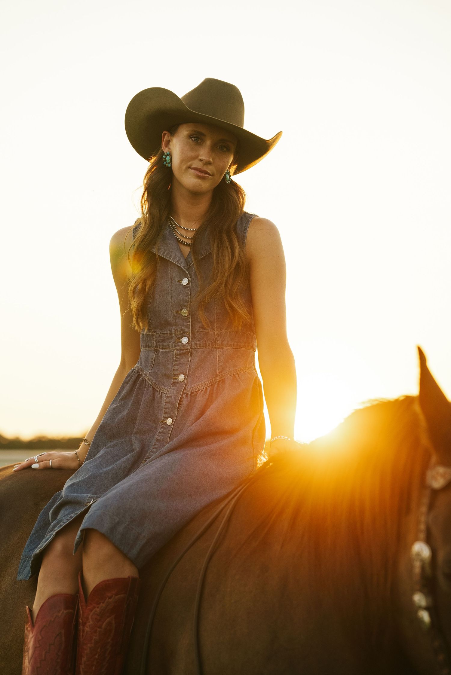 Golden hour equine portrait photography in Weatherford, Texas, featuring a girl on her horse wearing a cowboy hat.