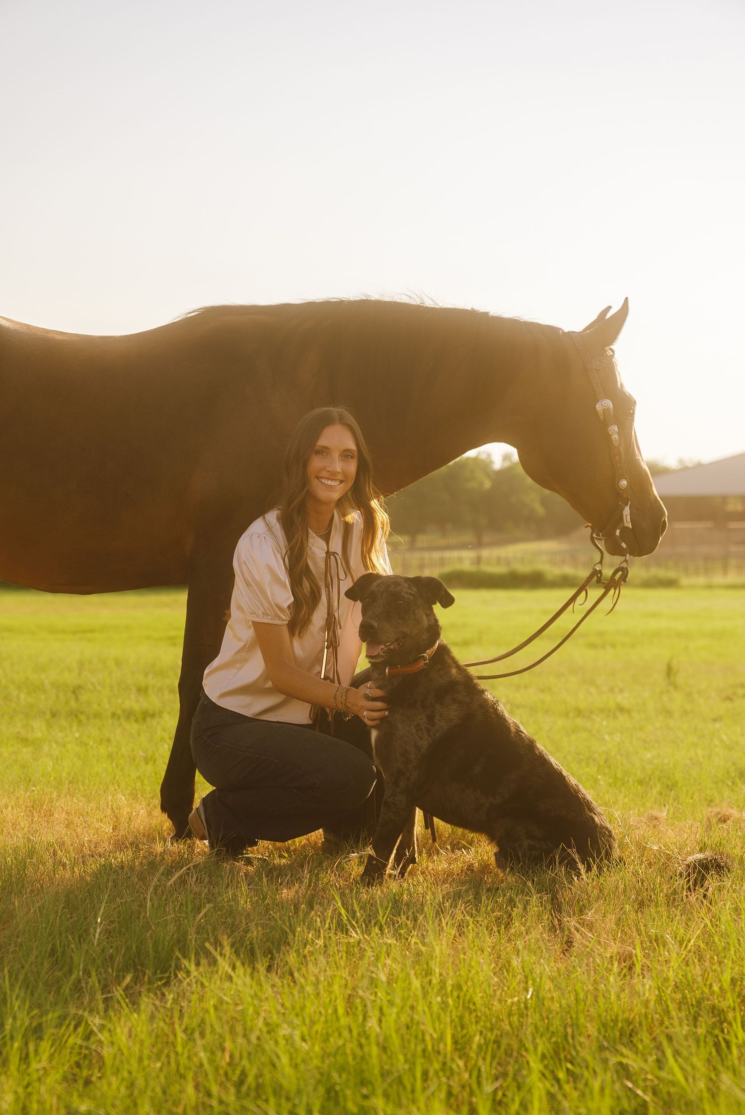 Golden hour portrait photography in Weatherford, Texas, featuring a girl with her horse and dog in a field.