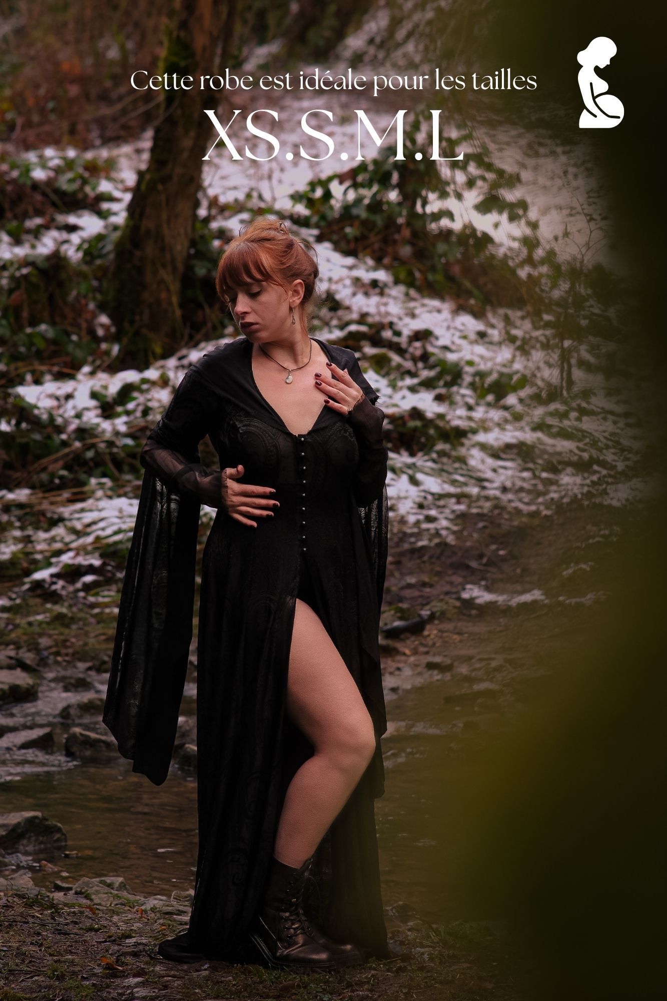 Woman in black gothic dress with bell sleeves poses in snowy forest, available in sizes XS, S, M, L.