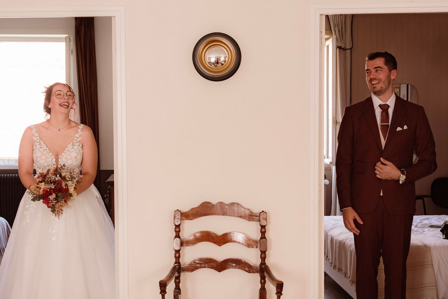 Bride and groom share a joyful first look moment in a bright room before their wedding ceremony.