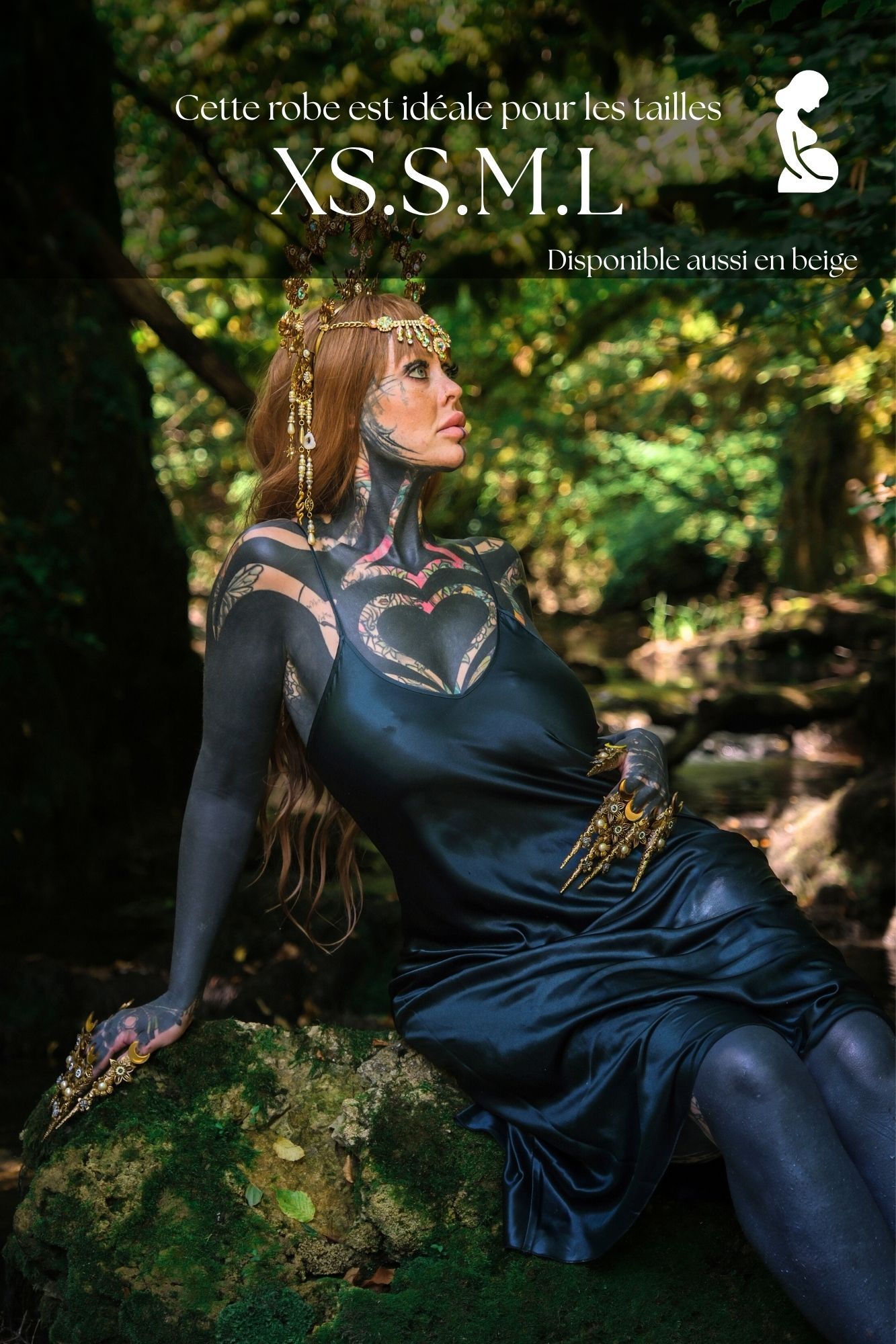 A model in a dark fantasy forest setting wearing a black satin dress, available in sizes XS, S, M, L.