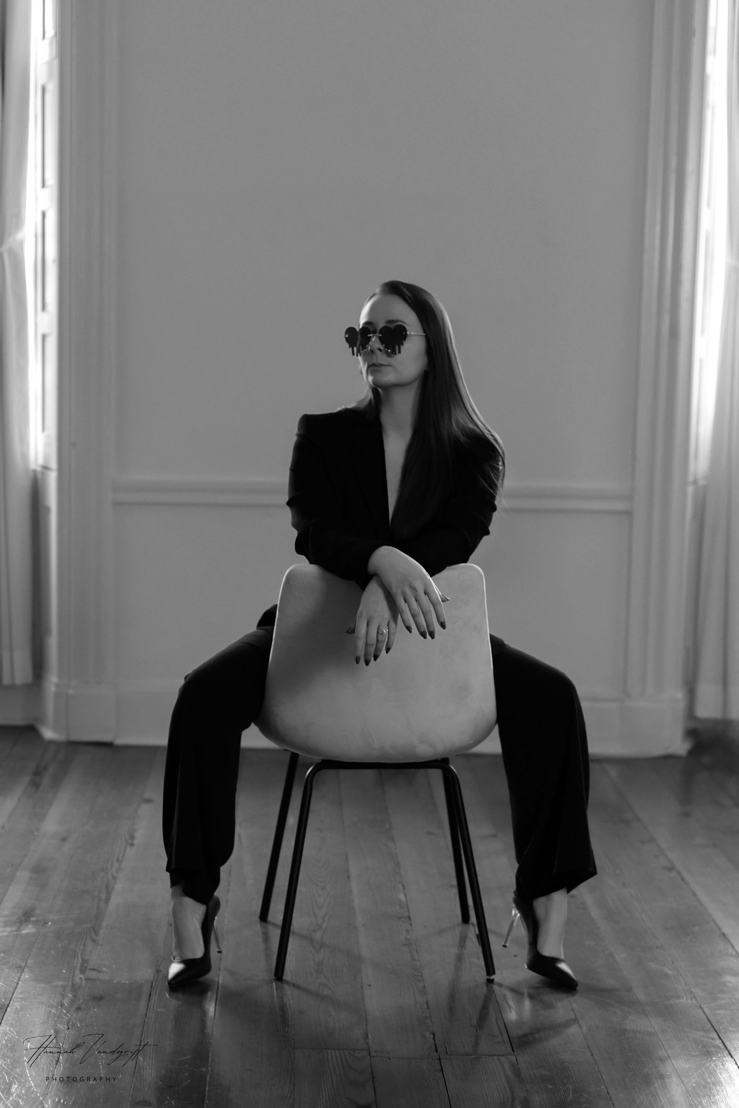 Minimalist photo series of seated poses on chair against white walls and wooden floor.