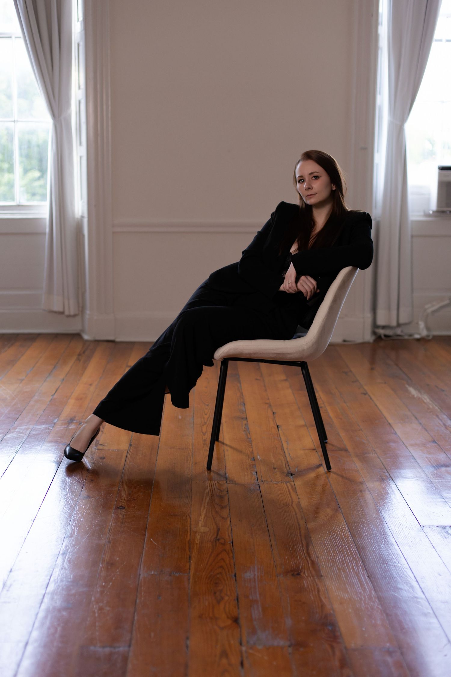 Contemporary dance-inspired poses with a chair on hardwood floors in natural light.