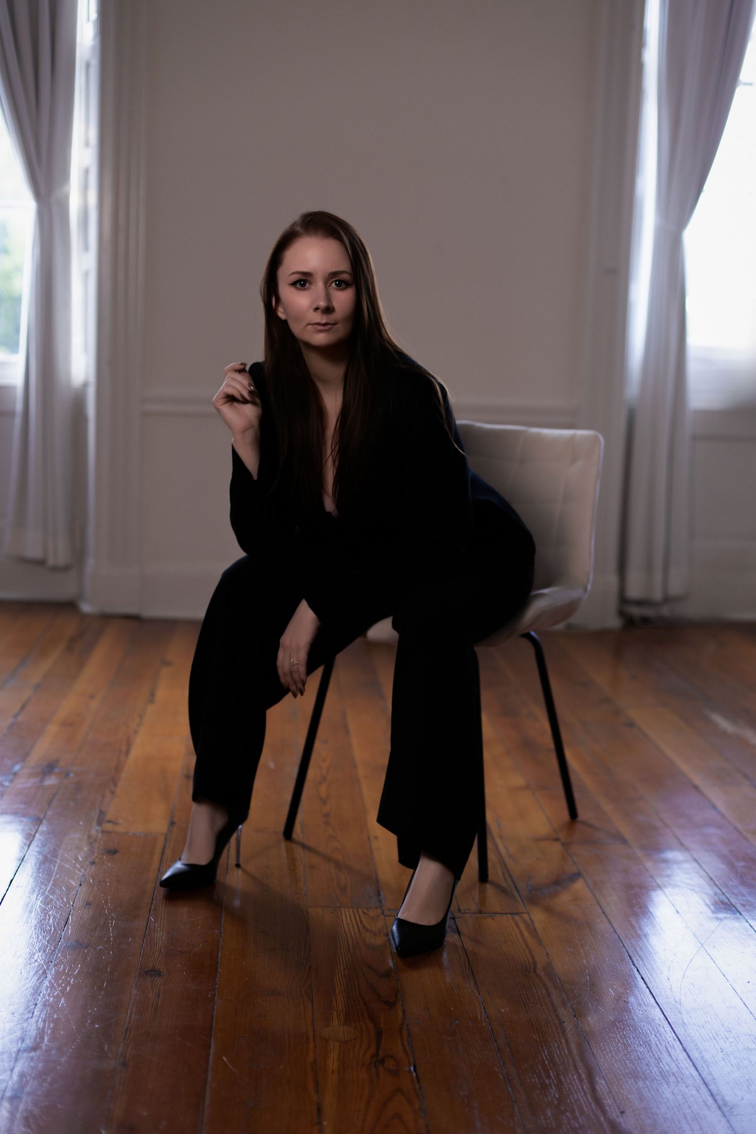 Sequence of artistic poses on a chair against white walls and wooden flooring.