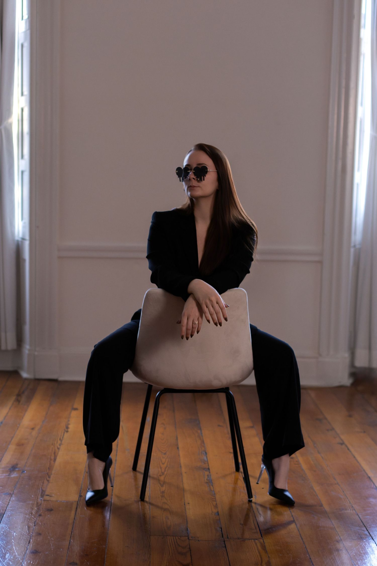 Artistic portrait series showing various seated poses on a chair in a bright minimalist room.