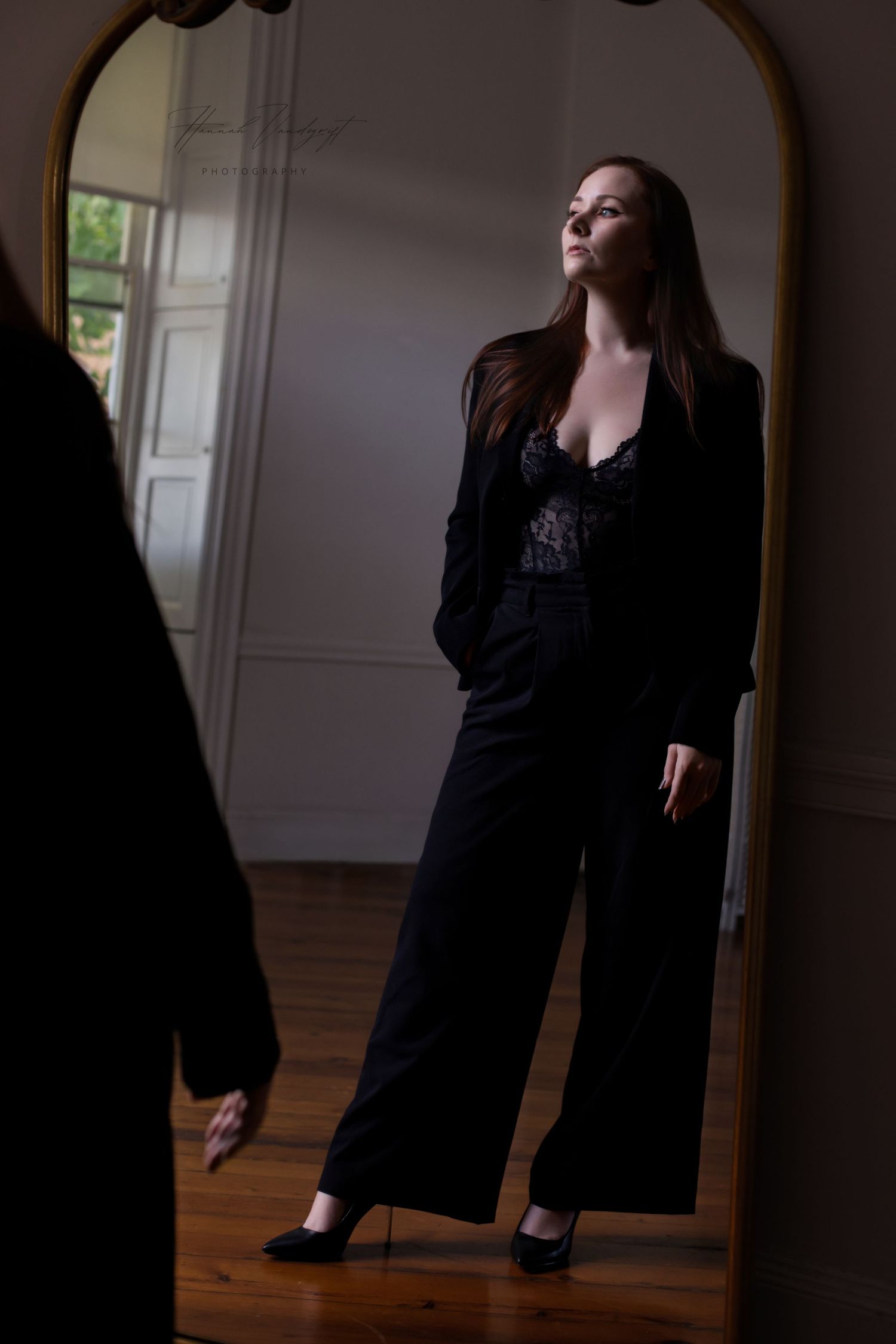 Dramatic series of poses in black clothing against a dark mirror and wooden floor.