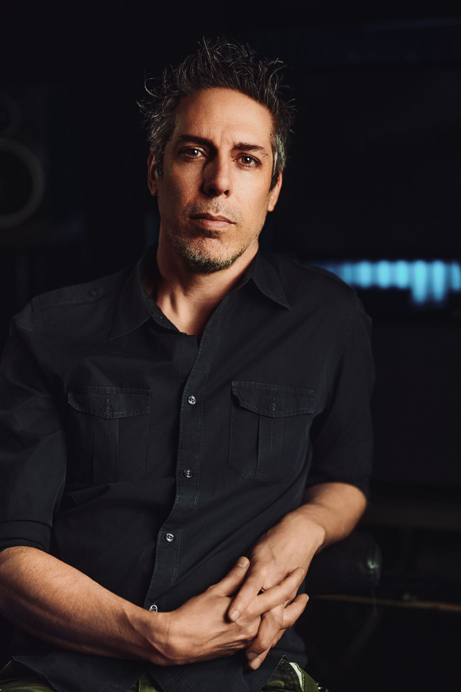 A series of dramatic black and white portraits showing a person in a dark shirt against a moody background.