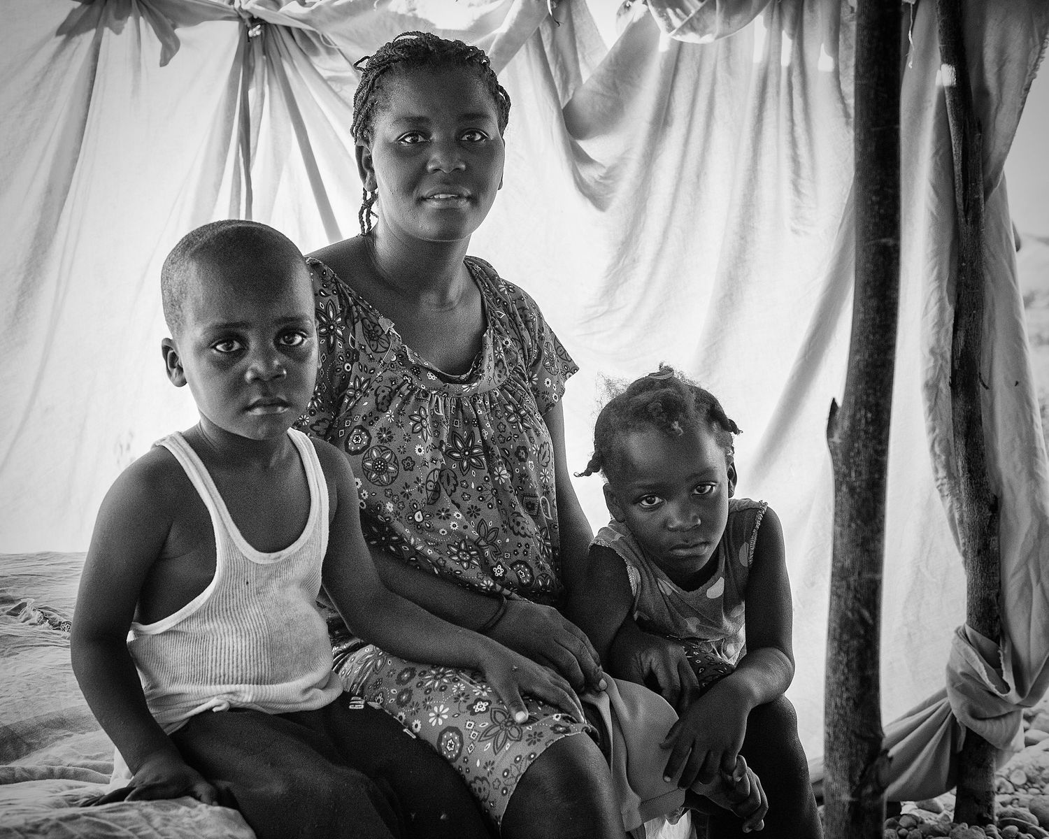 A woman and her two children beneath a temporary shelter in Fond Parisien, Haiti, Sept. 2013. (Afonso Salcedo)