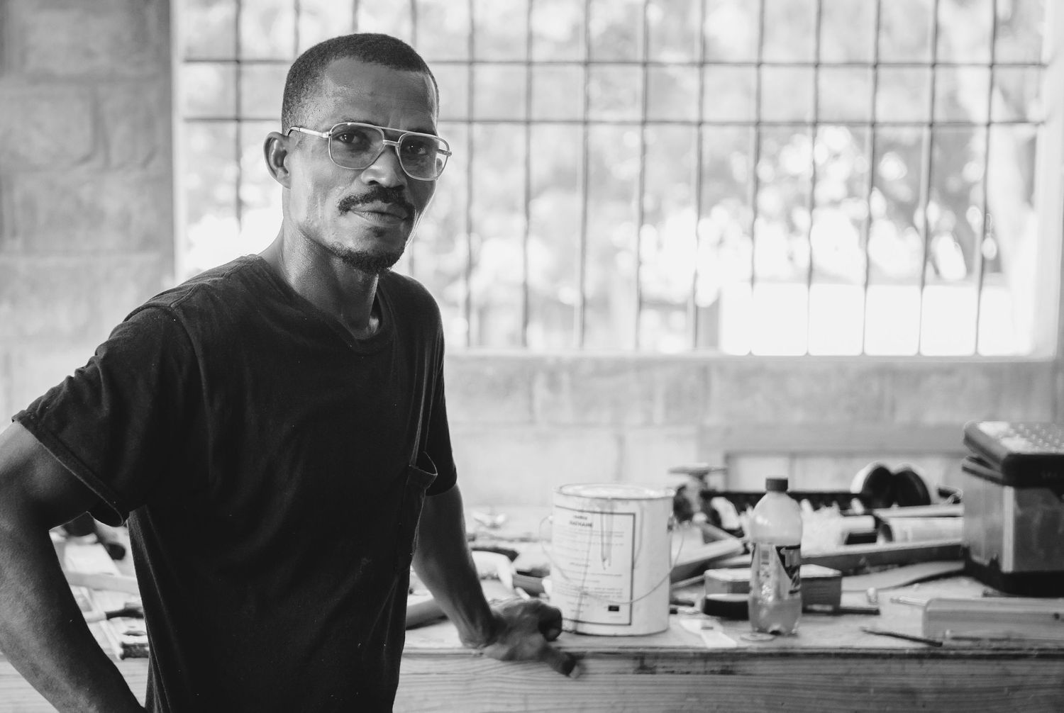 Black and white environmental portrait in workshop with natural window light — editorial portrait by Los Angeles photographer Afonso Salcedo