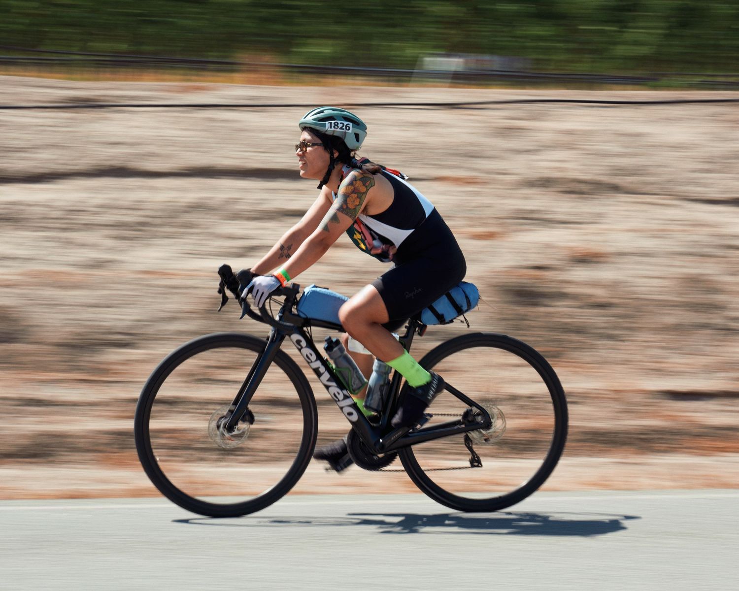 Side view of cyclists in racing positions speeding along a road captured with motion blur.