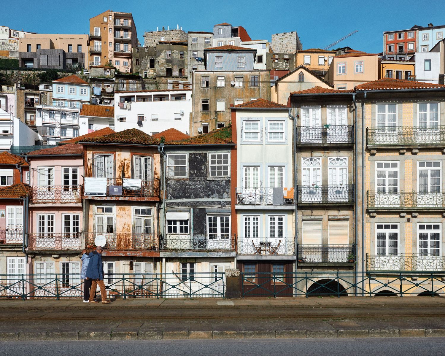 Panoramic view of colorful historic buildings along the Douro River waterfront in Porto, Portugal.