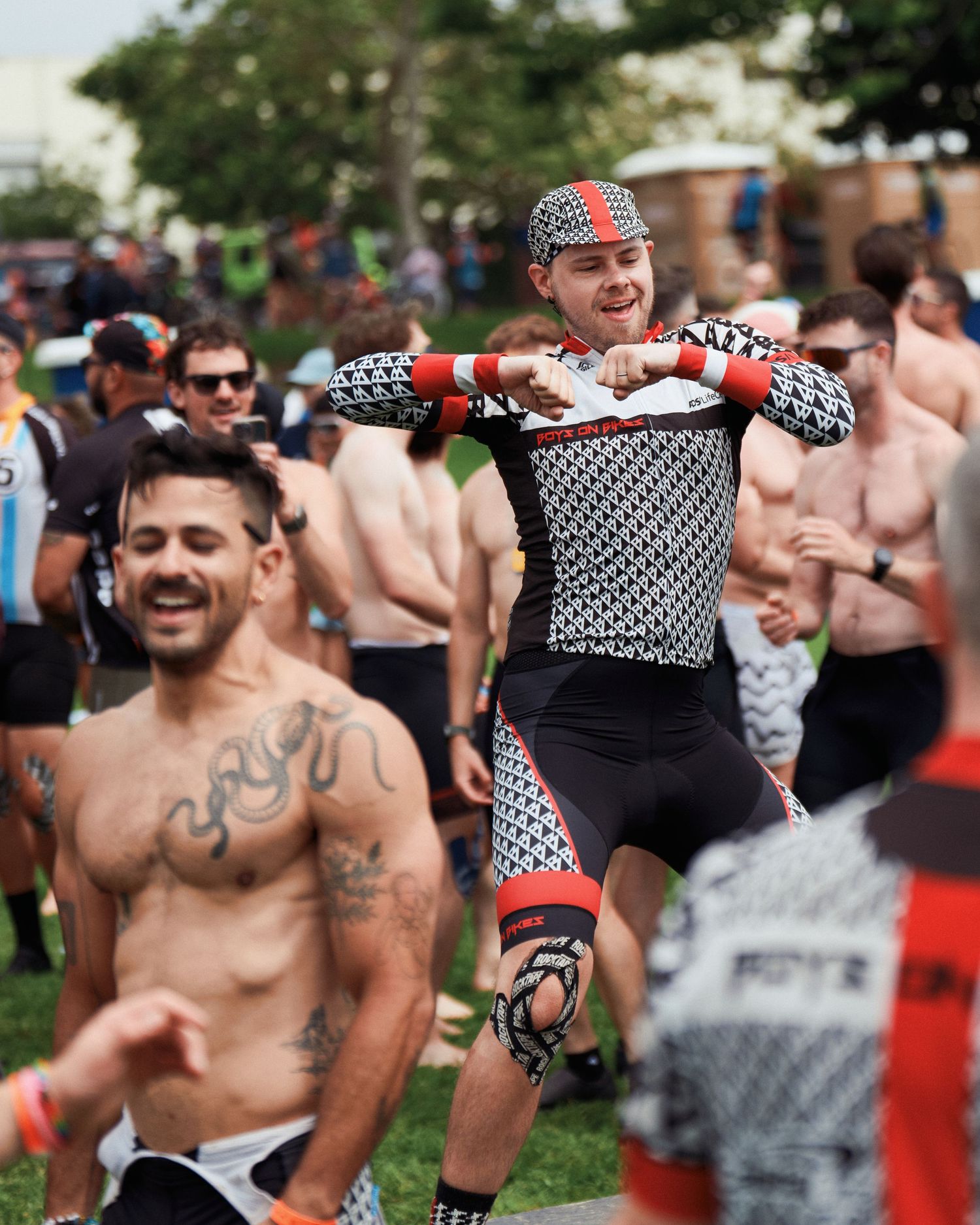 Energetic crowd enjoying an outdoor event with people wearing black and white patterned accessories.