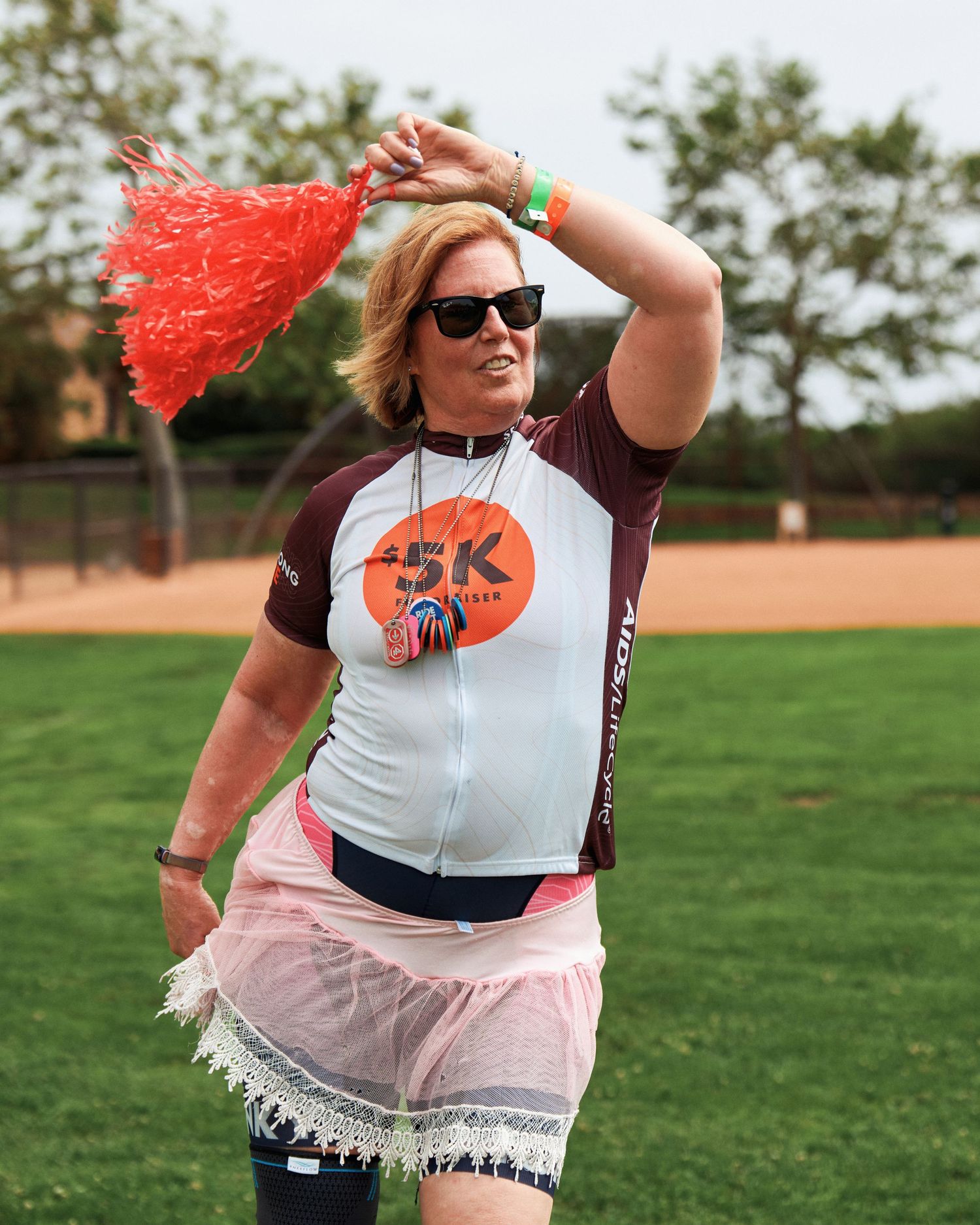 Participants in white and maroon outfits with tutus participating in an outdoor athletic event.