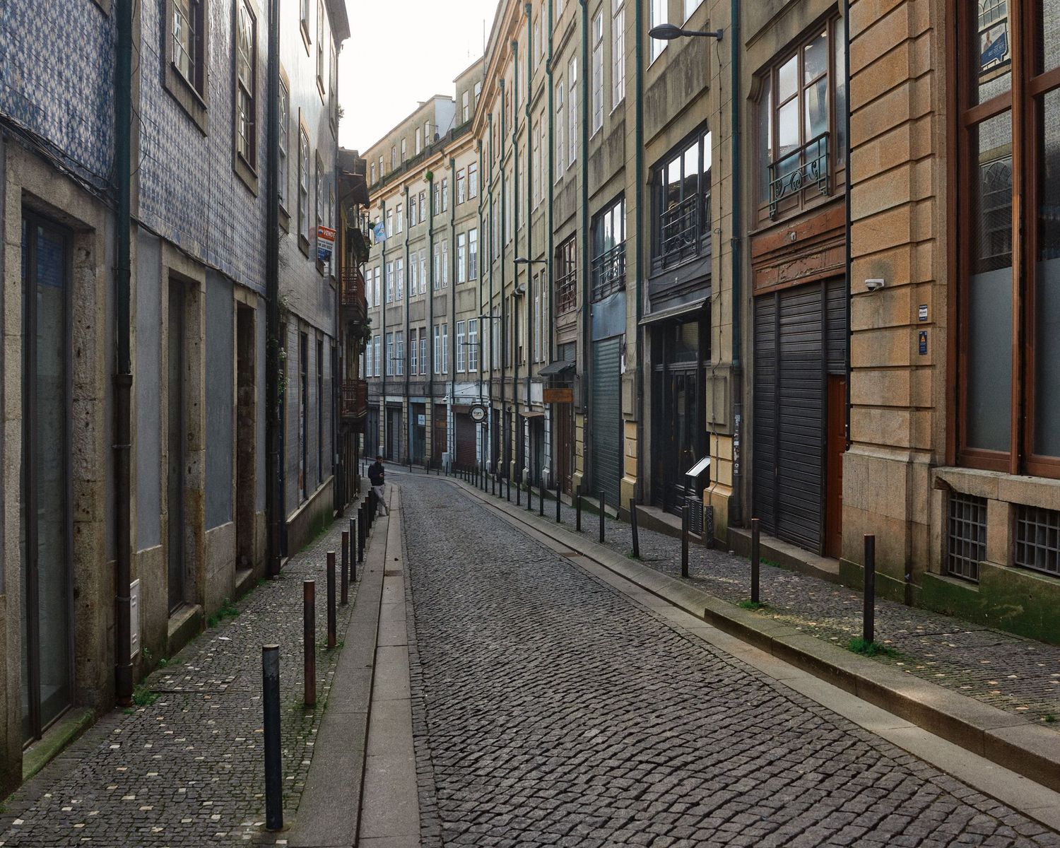 Narrow cobblestone street with historic buildings and traditional architecture in European city center.