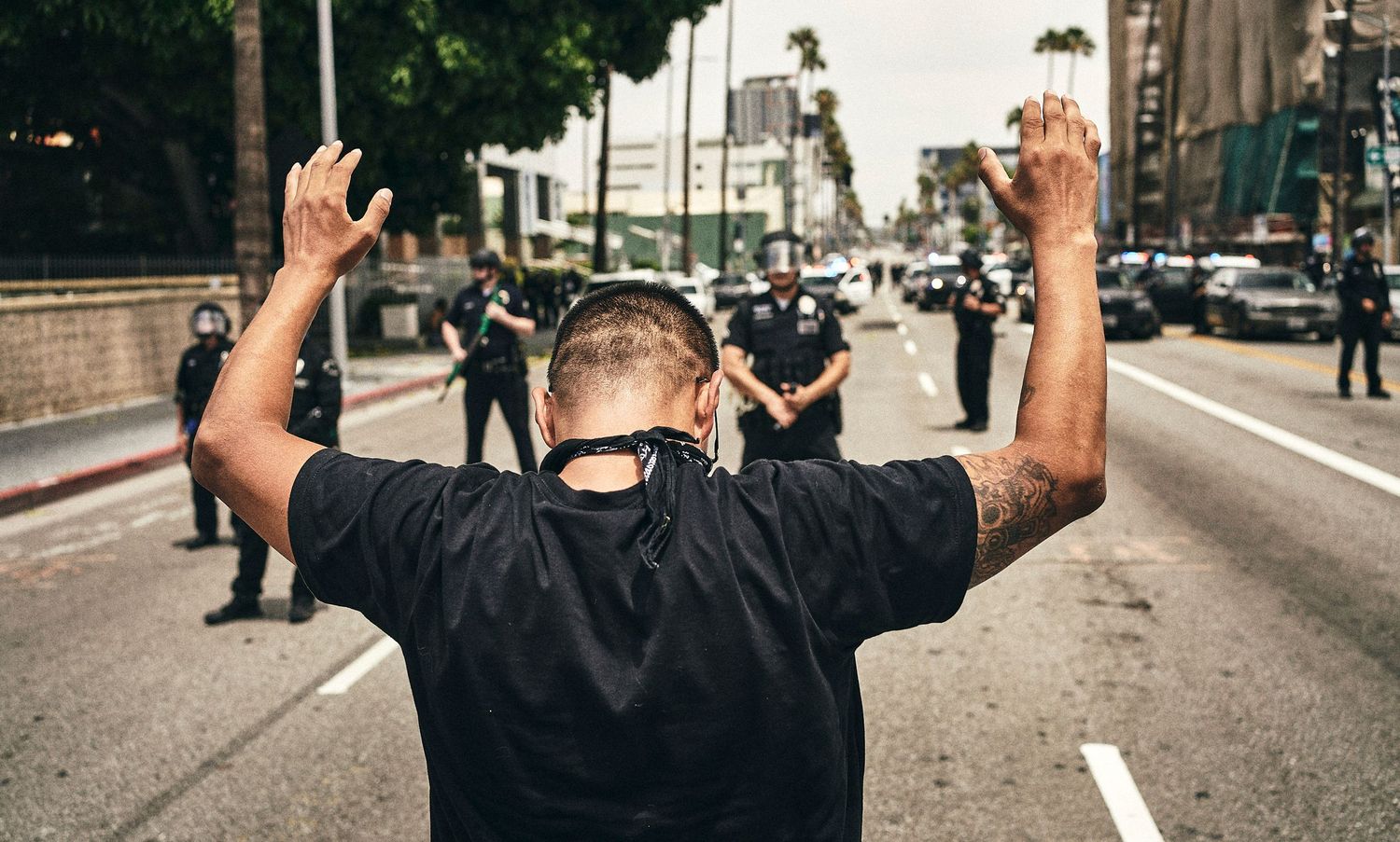 A protester faces a police line with hands raised during a BLM demonstration in Los Angeles, June 2020. (Afonso Salcedo)