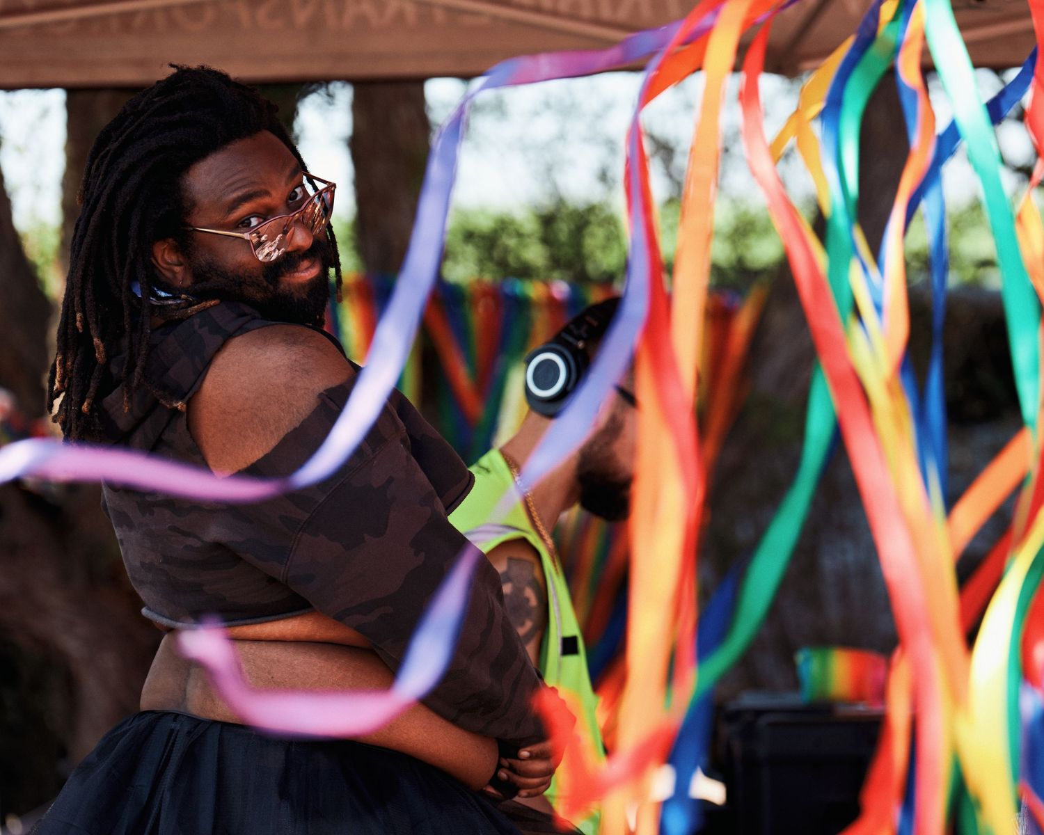Colorful streamers and ribbons create festive motion blur against a dark background.