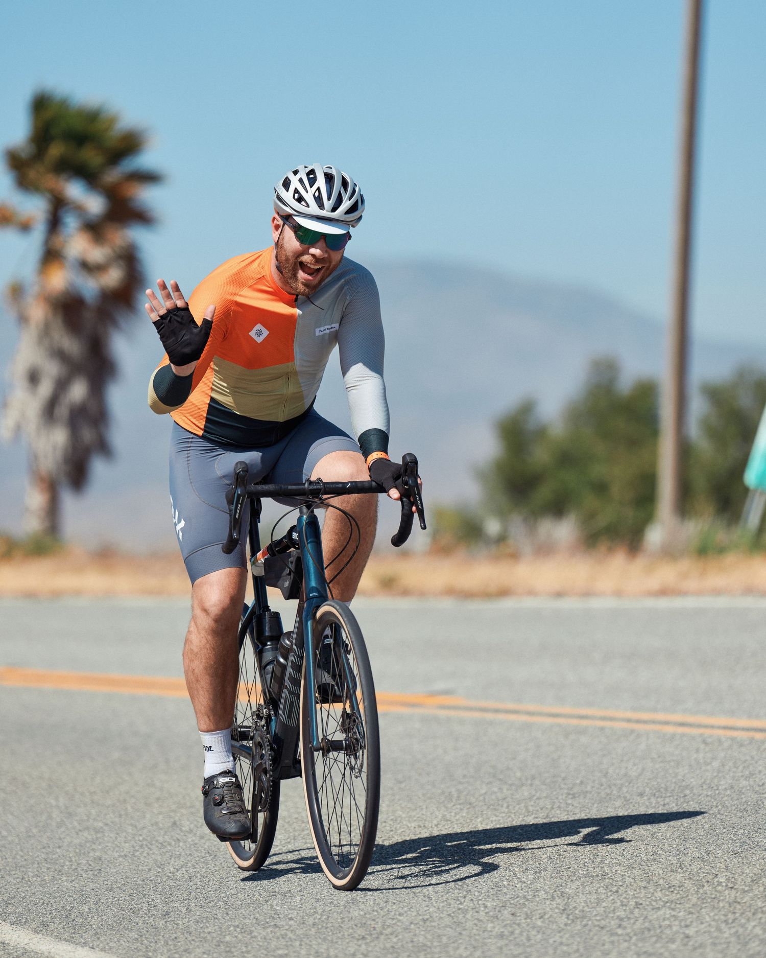 Multiple shots of cyclists training on a desert road with palm trees and mountains in the background.