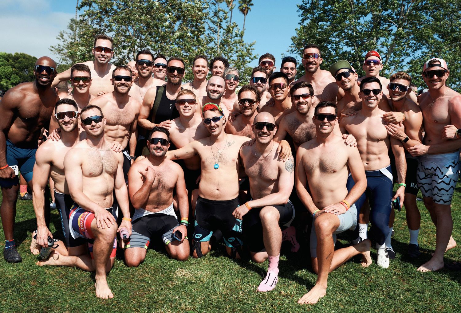A large group of shirtless spectators gathered outdoors on a sunny day at a sporting event.