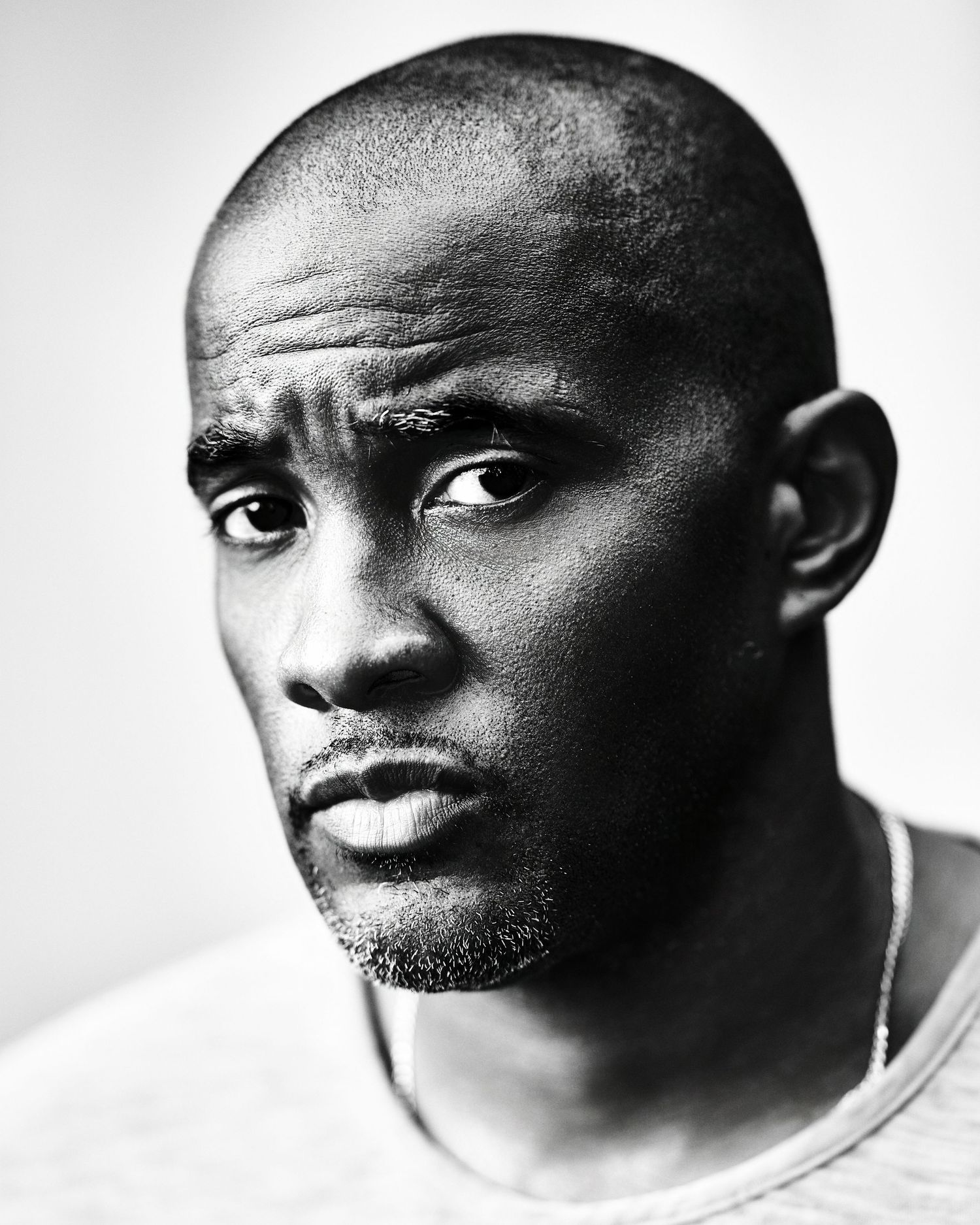 Black and white portrait series showing different facial expressions and angles in dramatic lighting against white background.