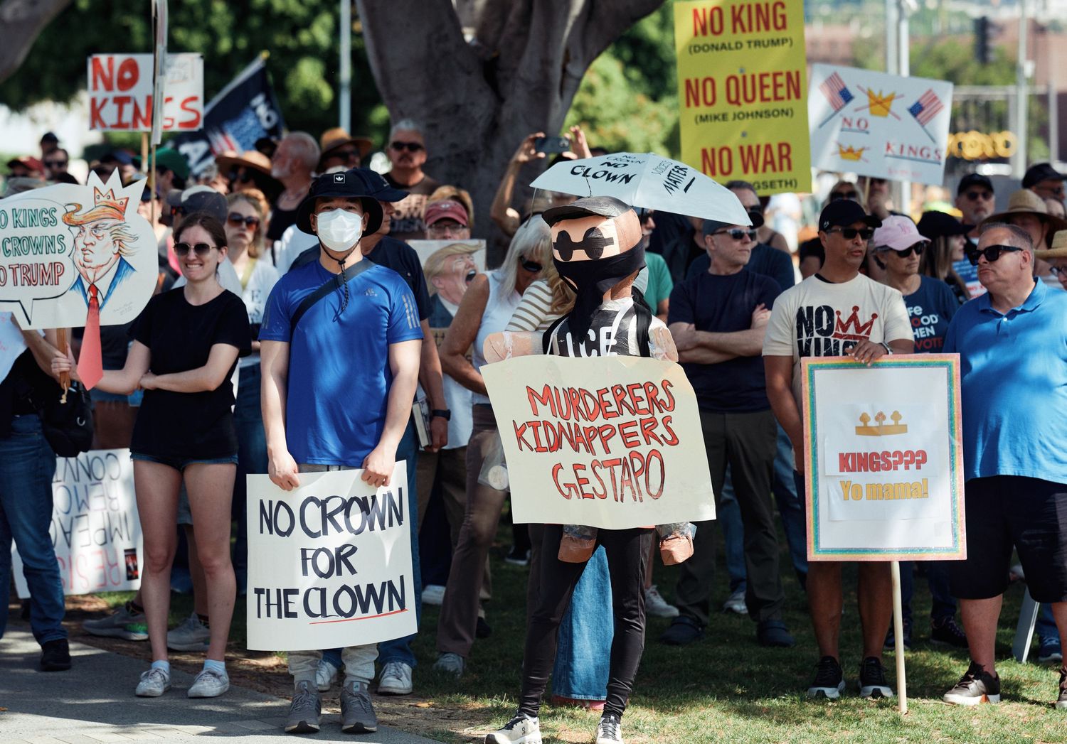 Demonstrators hold signs at the No Kings protest in West Hollywood, March 28, 2026. (Afonso Salcedo)