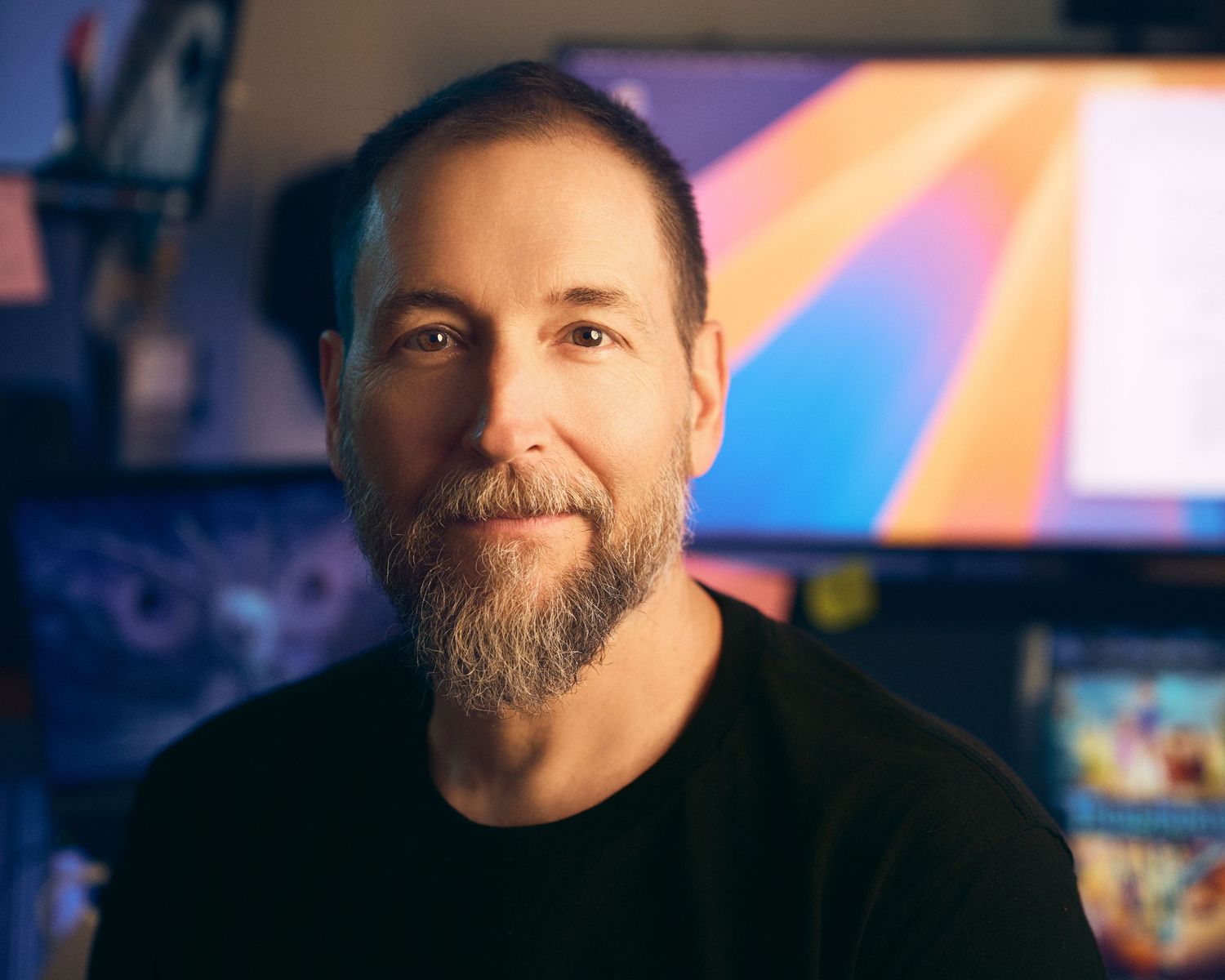A bearded man in front of a colorful blurred background appears in a series of similar headshots.