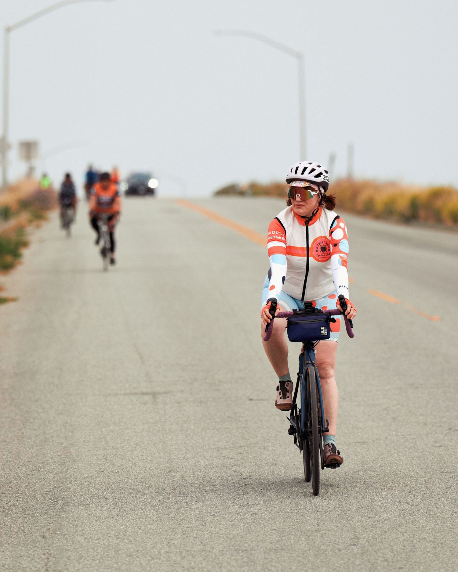 Cyclist on a paved road cycling route shown from multiple angles against a blurred background.
